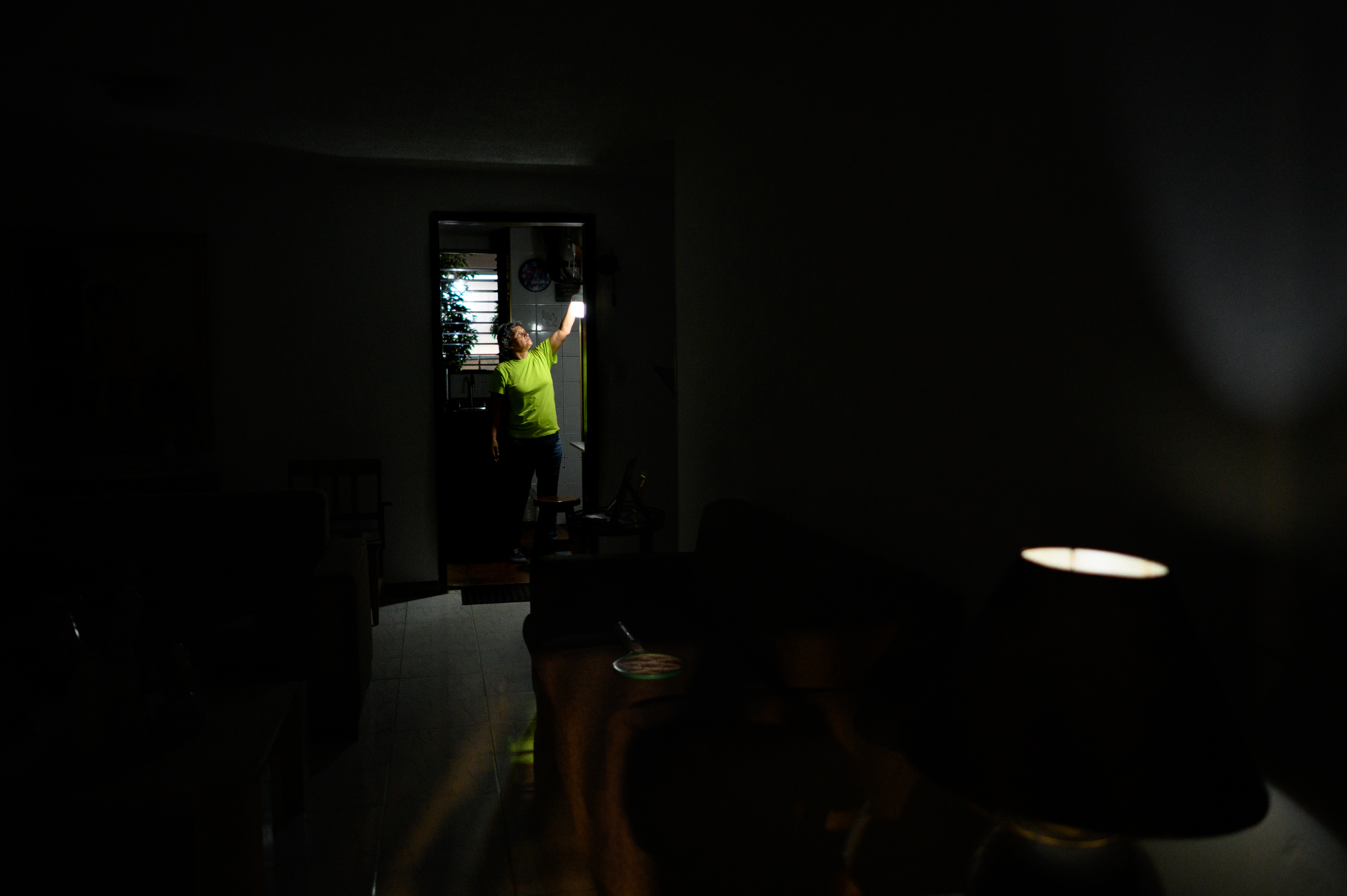 Carolina González acende uma lâmpada recarregável na cozinha de sua casa durante uma falha no serviço elétrico que deixou um setor sem energia elétrica por vários dias na urbanização El Cafetal, Caracas, Venezuela, em 7 de setembro de 2023.
