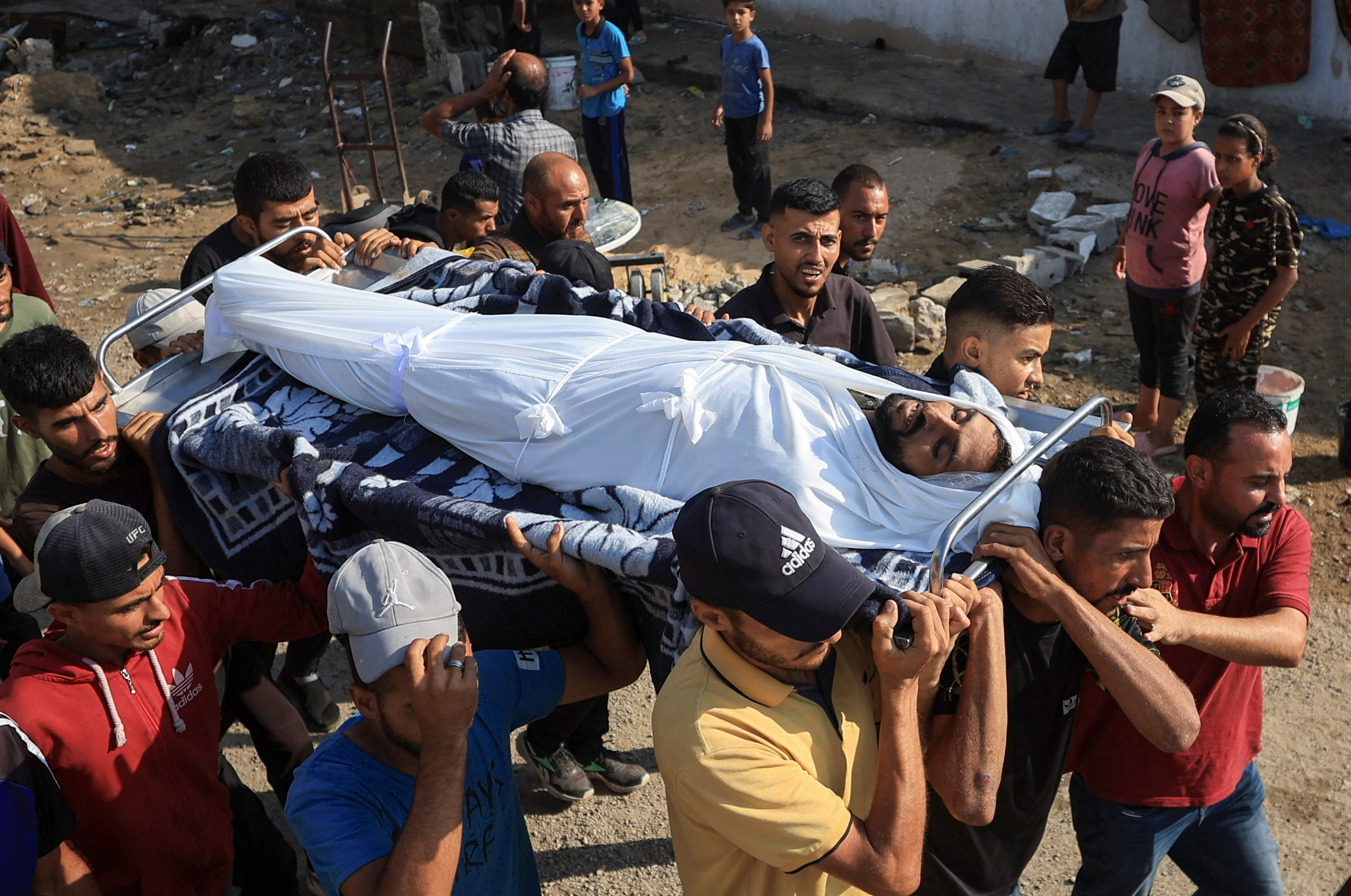 Un grupo de personas carga el cuerpo de un hombre asesinado por un ataque israelí en Ciudad de Gaza, este lunes 25 de agosto.