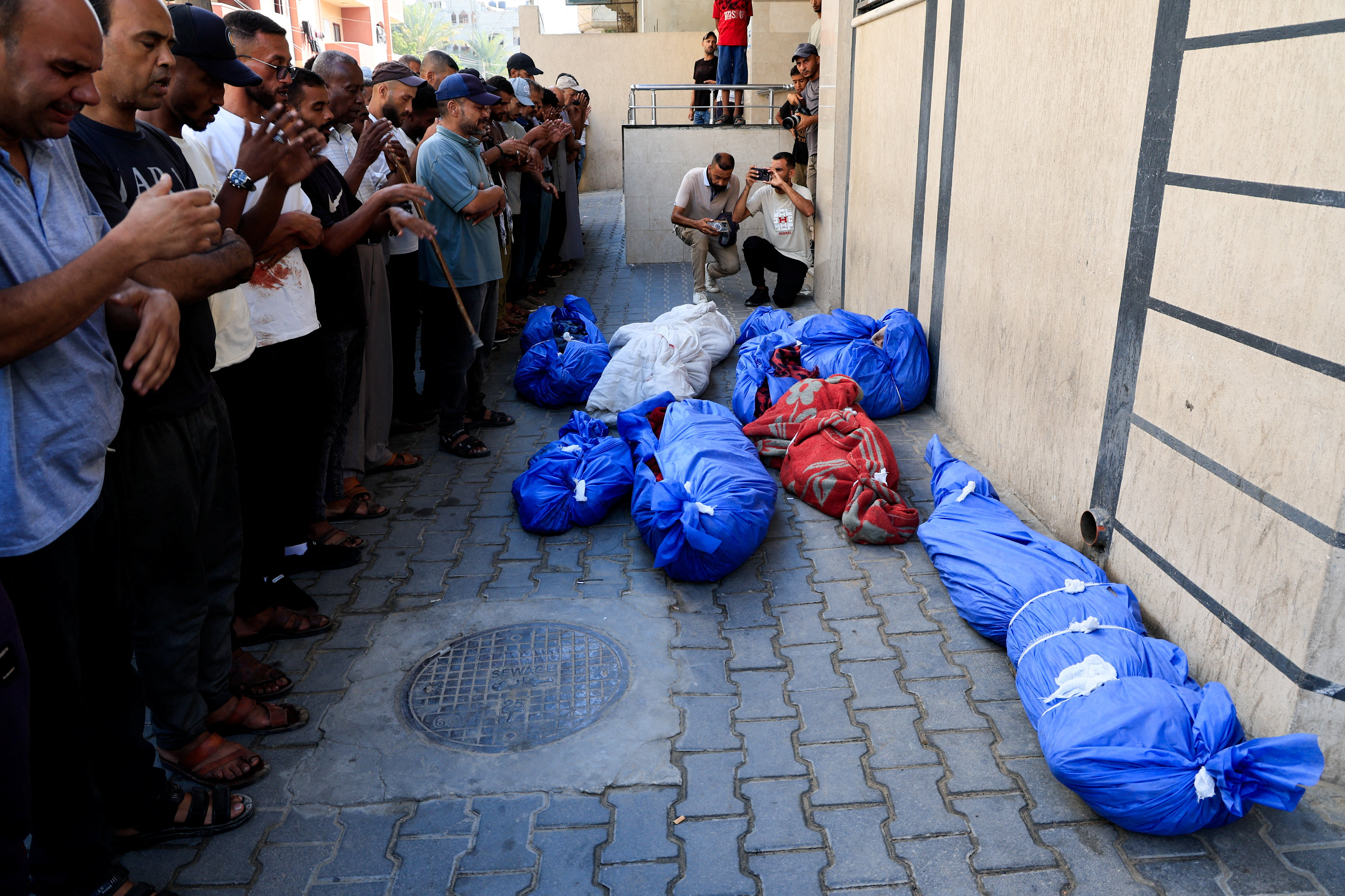 Un grupo de personas reza en el funeral de palestinos asesinados en un ataque israelí en Nuseirat, en el centro de la Franja, este martes 29 de julio.