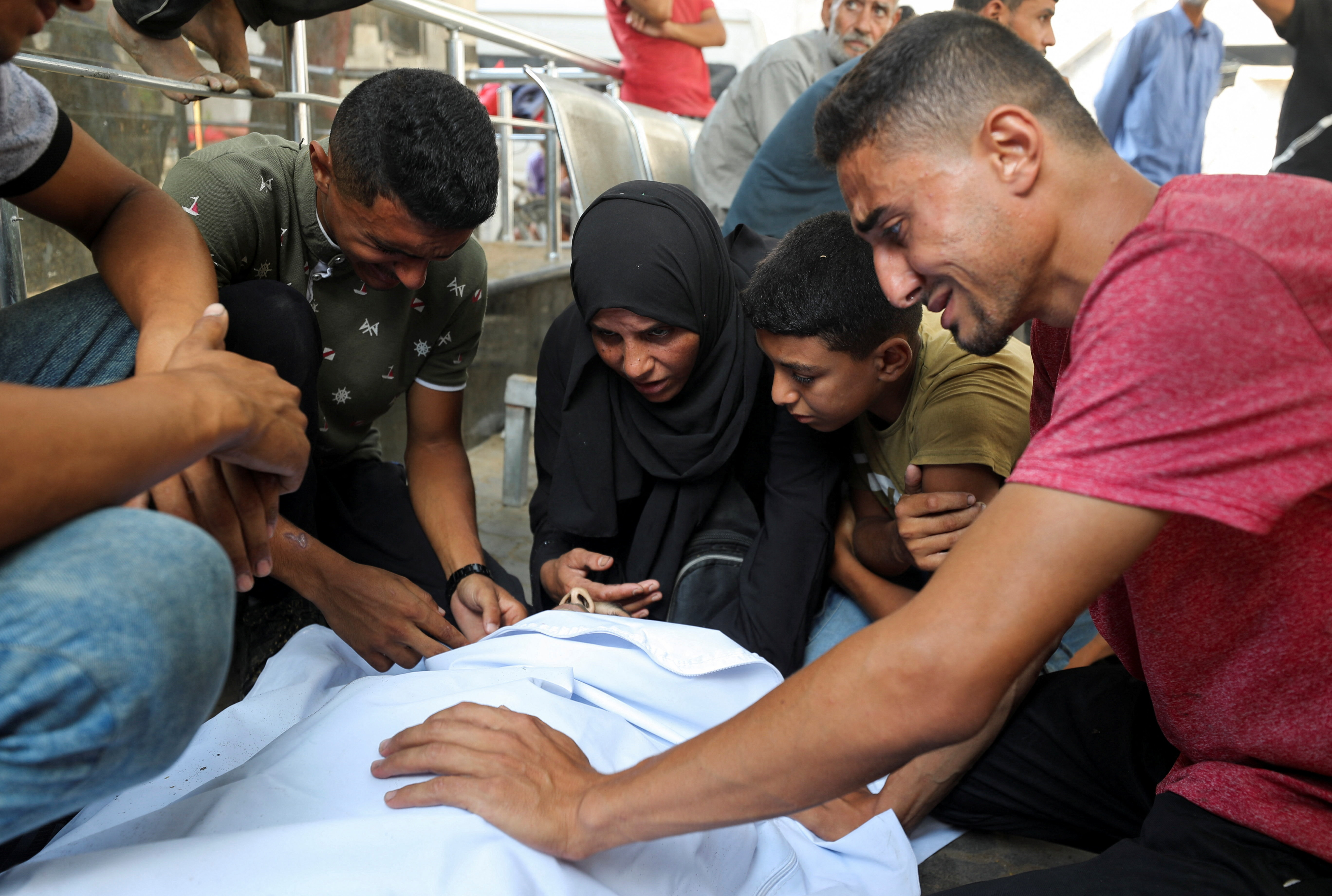 Un grupo de personas junto al cadáver de un palestino asesinado mientras intentaba acceder a alimentos el lunes, en el hospital Al Shifa, en Ciudad de Gaza, en el centro de la Franja, este martes 29 de julio.
