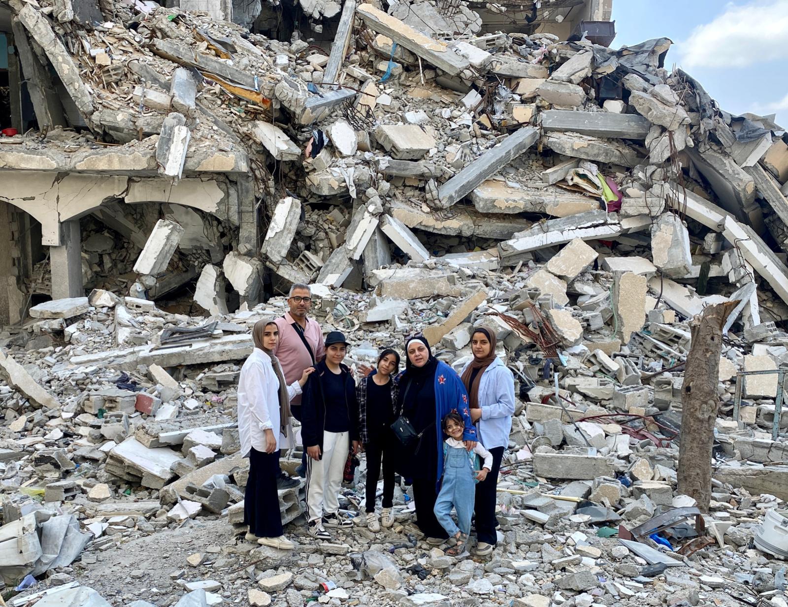 Malak Mohamed Hussein (a la izquierda), de 21 años, junto a su familia, en los escombros de su casa en Ciudad de Gaza, al norte de la Franja, en mayo de 2024.