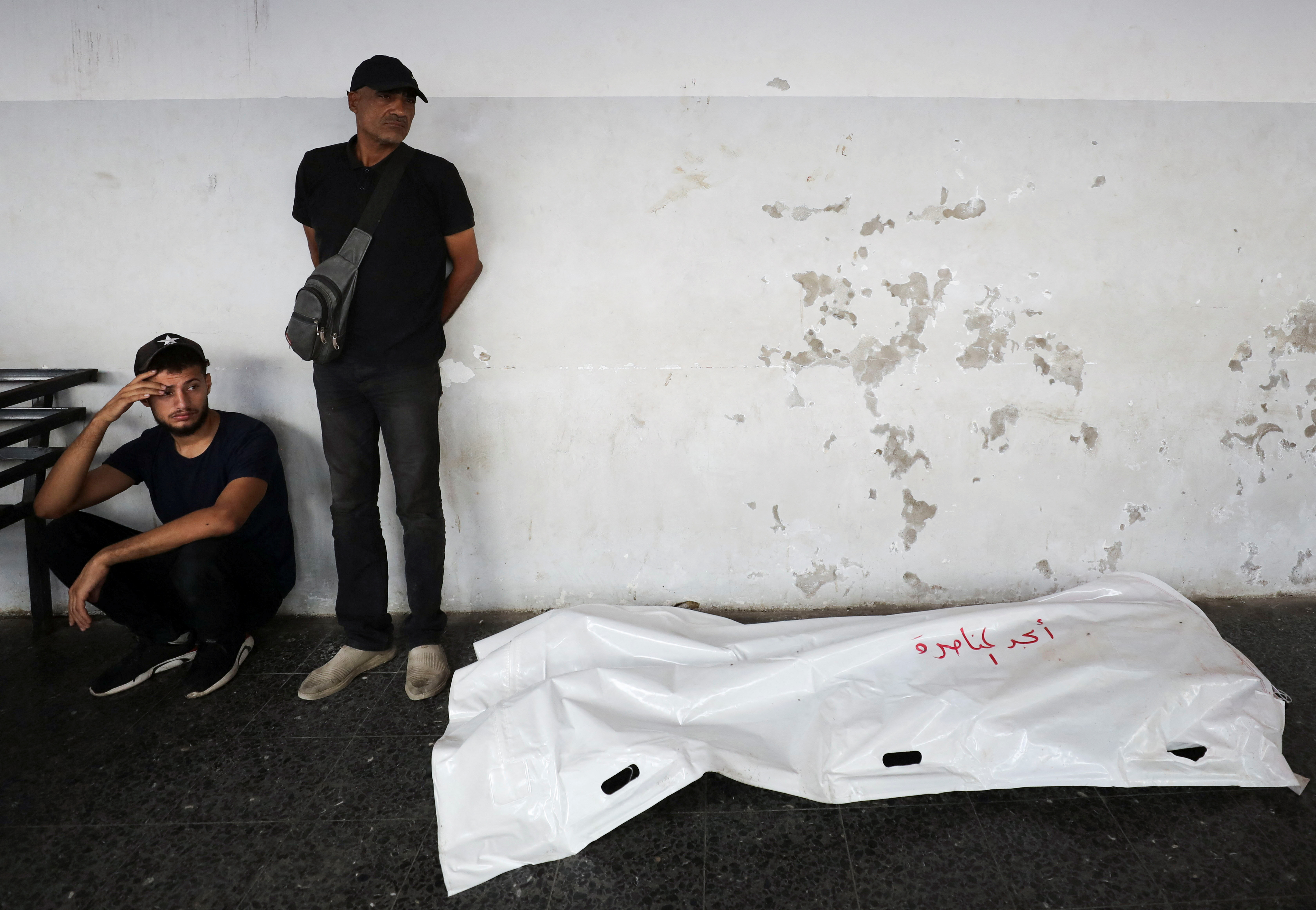 Dos palestinos junto a un cadáver en Ciudad de Gaza este viernes. 