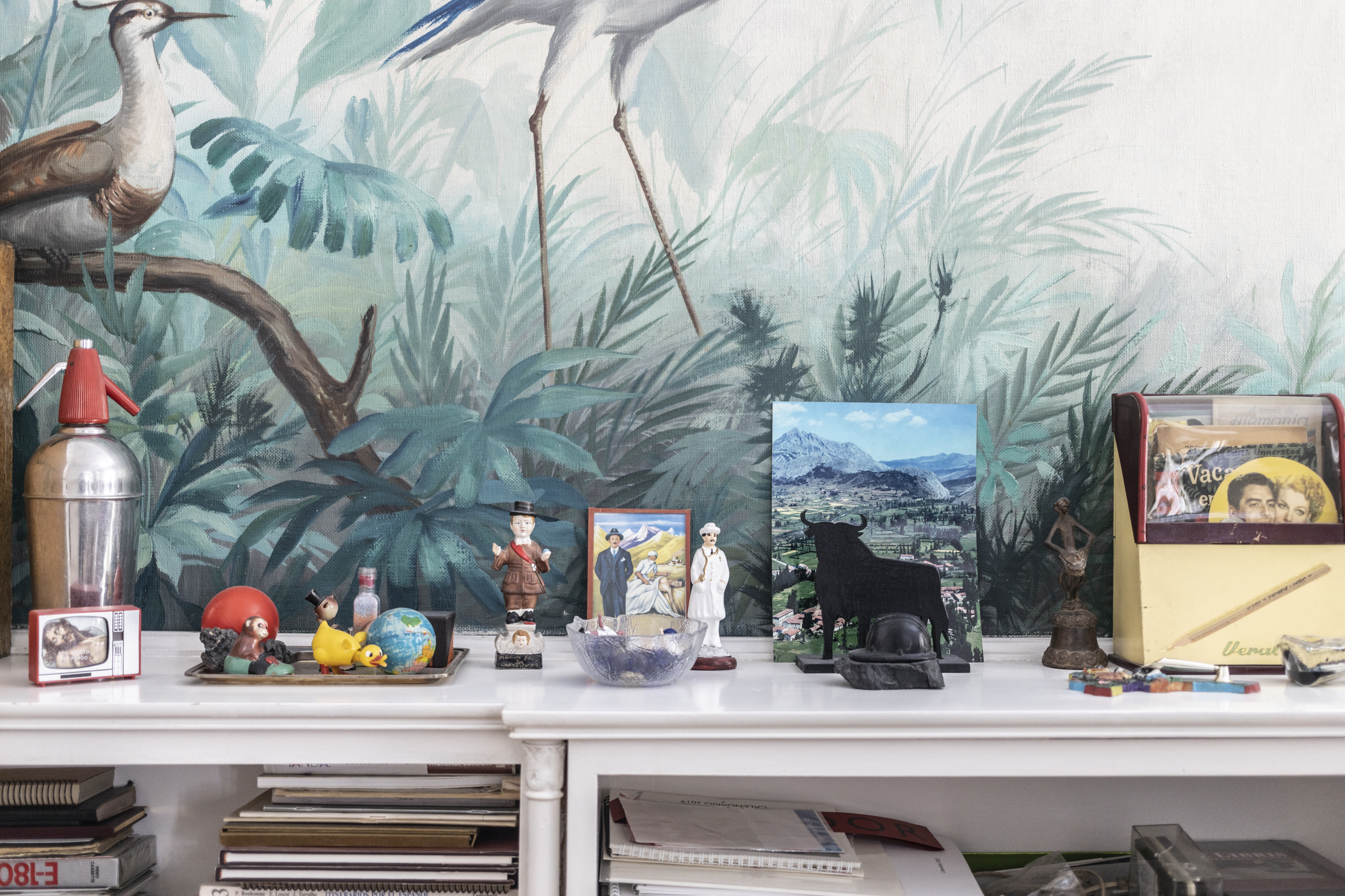 Varios objetos que decoran los estantes del despacho de Julio Llamazares. A la derecha, una foto de Vegamián, el pueblo donde nació y que hoy permanece desaparecido bajo el agua del embalse Juan Benet.