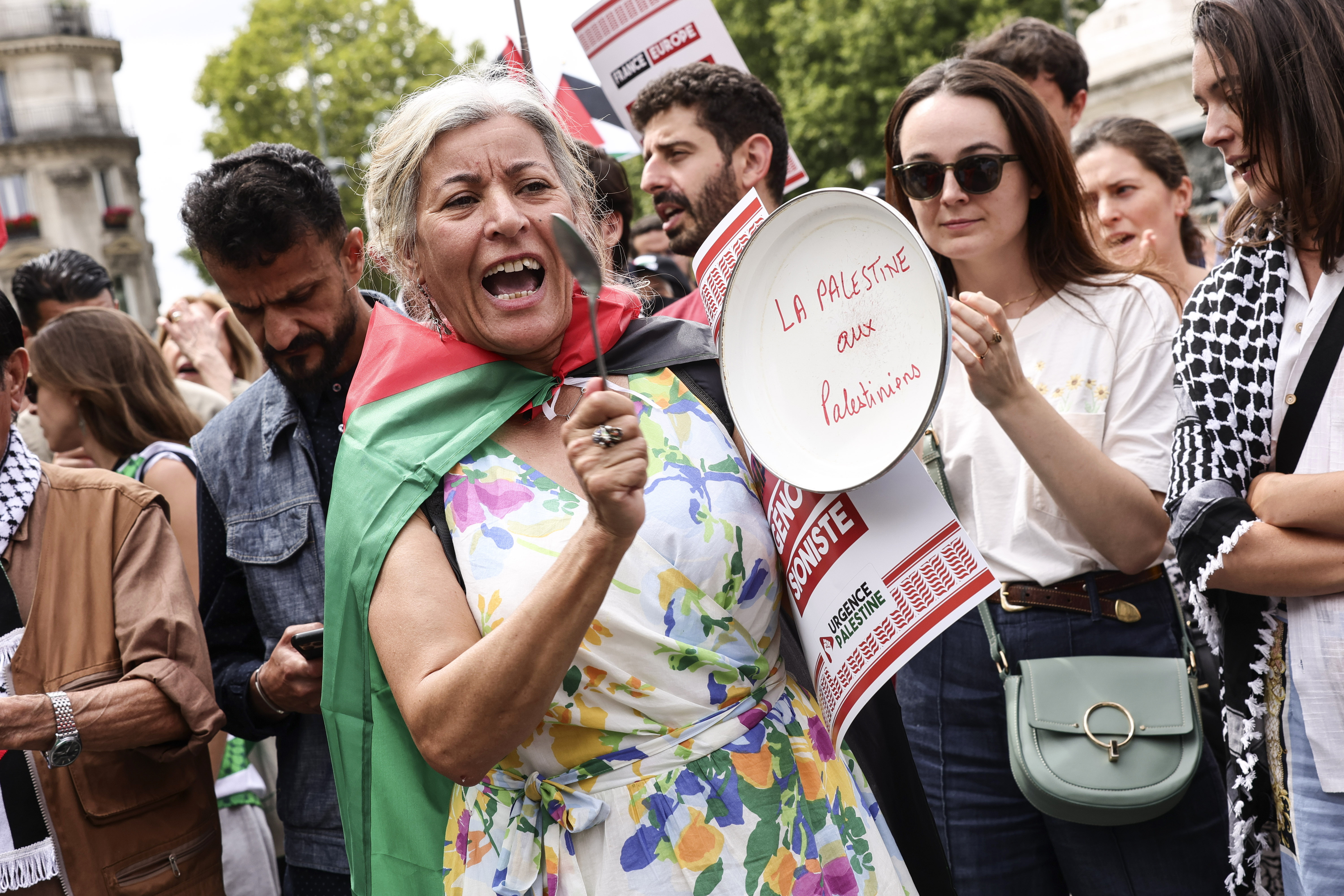 Una mujer golepea una sarten donde se lee "Palestina para los palestinos", durante la manifestación de este sábado en París.