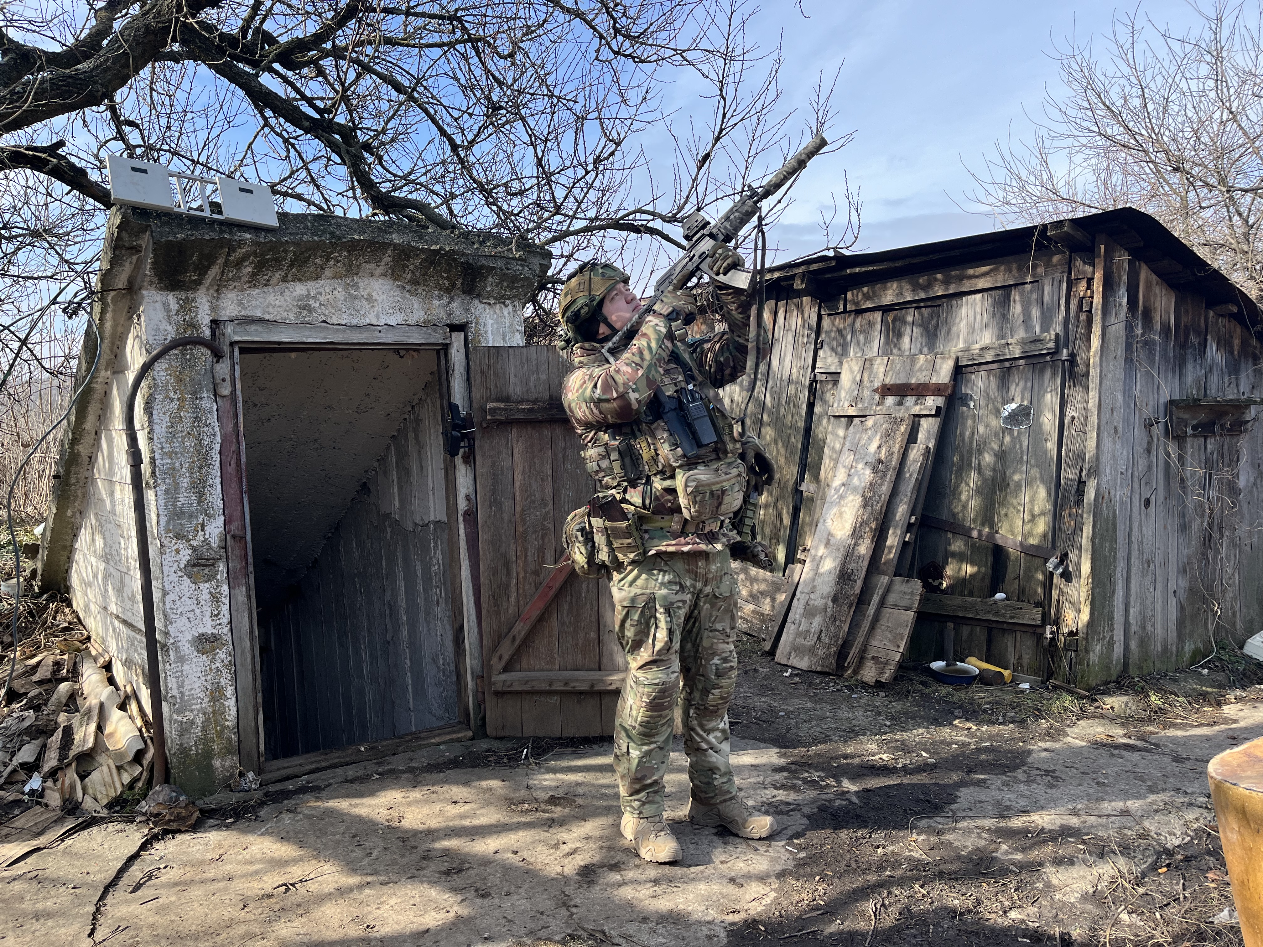 Oleksii, um dos membros da unidade de reconhecimento aéreo OCHI, que trabalha com seus drones na frente de Bakhmut, aponta seu rifle para um drone russo. 