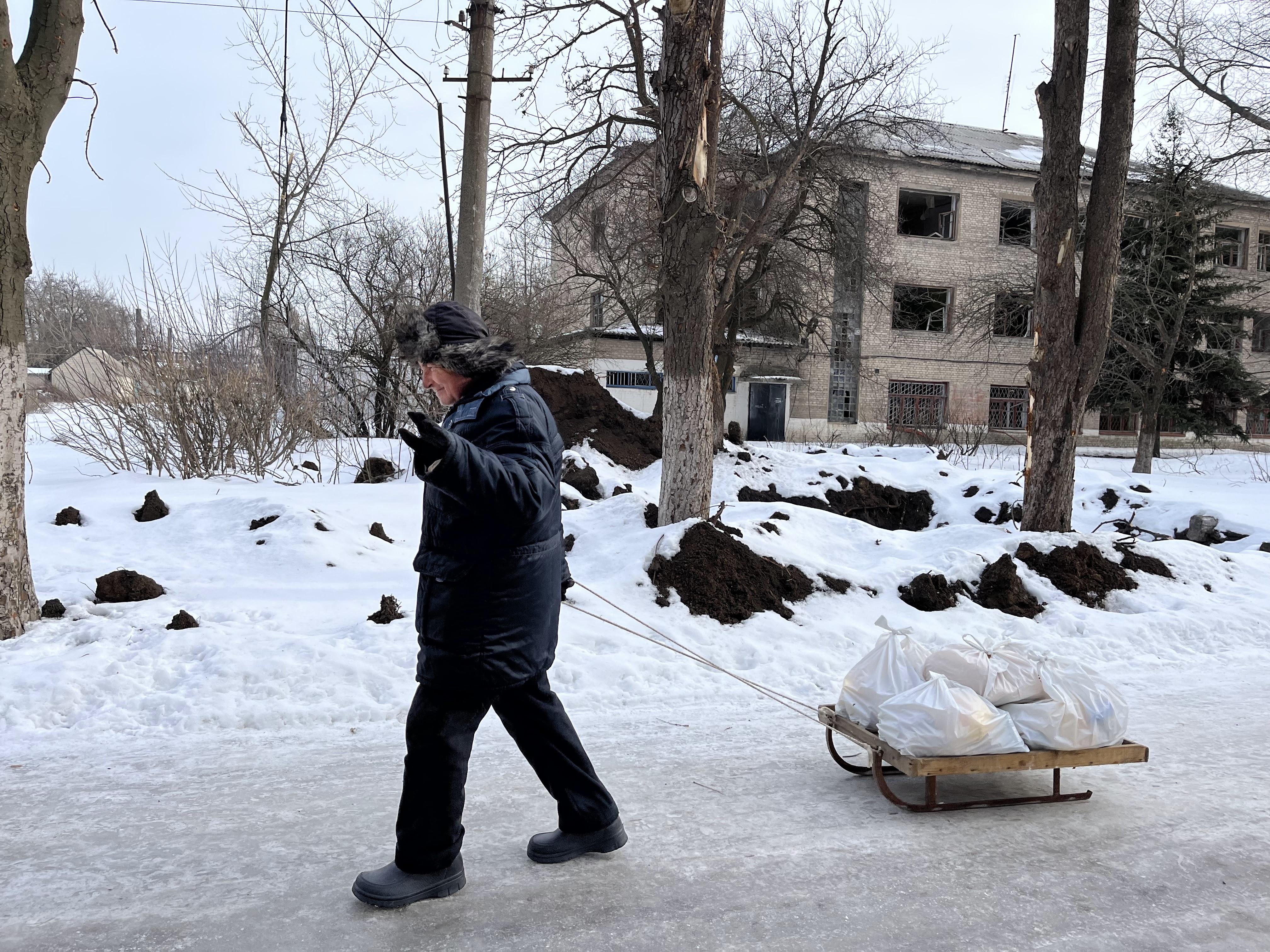 Um homem carrega ajuda humanitária em Chasiv Yar. /SRA