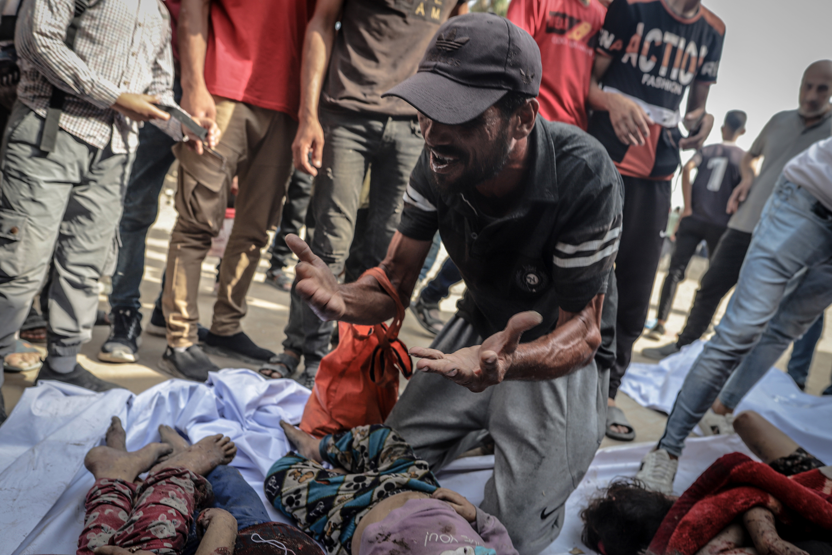 Un hombre llora sobre los cuerpos de varios niños asesinados en ataques israelíes en Ciudad de Gaza, en el norte de la Franja, este lunes 11 de agosto.