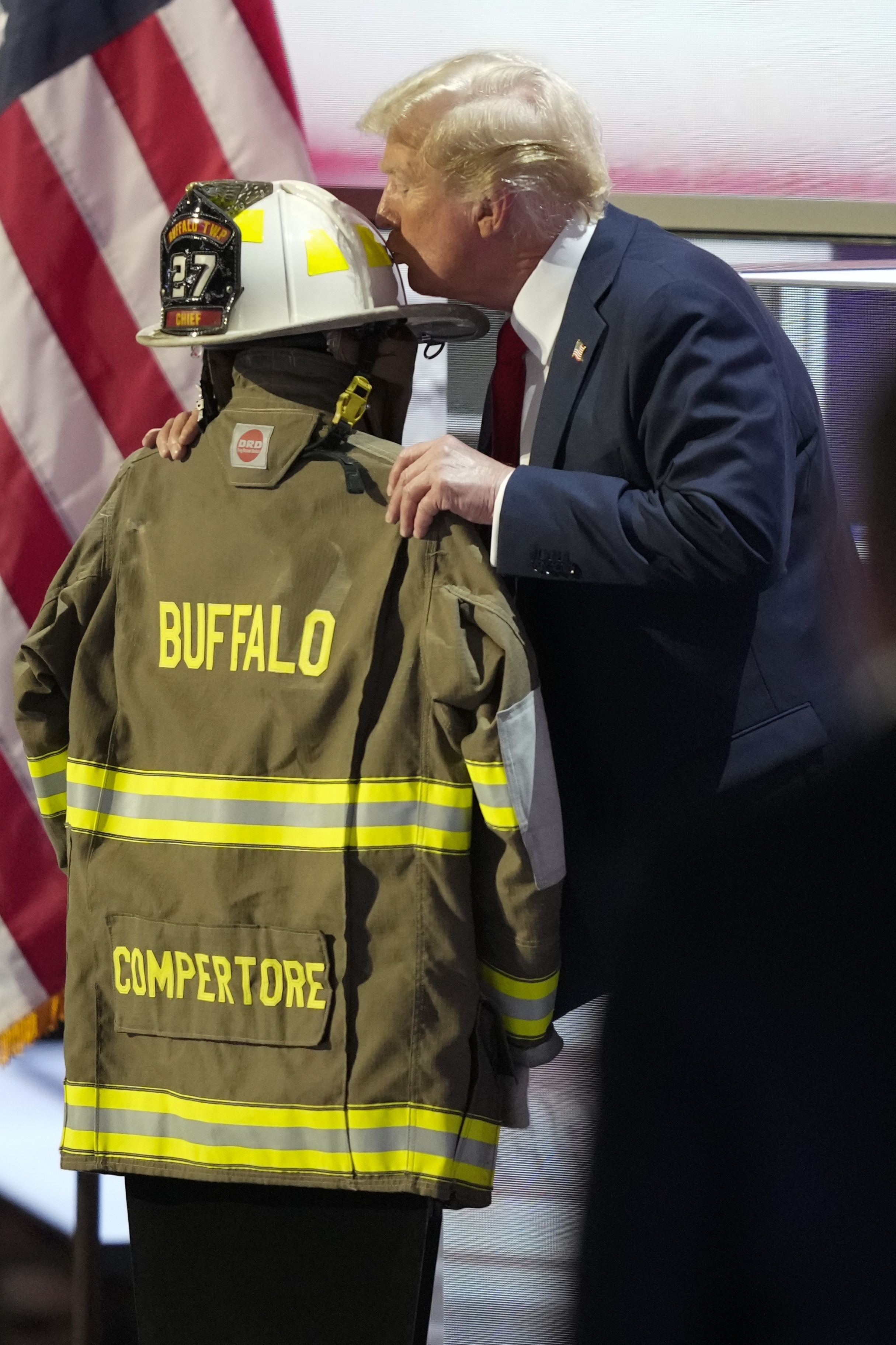 Republican presidential candidate former President Donald Trump kisses the helmet of Corey Comperatore during the Republican National Convention Thursday, July 18, 2024, in Milwaukee. (AP Photo/Charles Rex Arbogast)