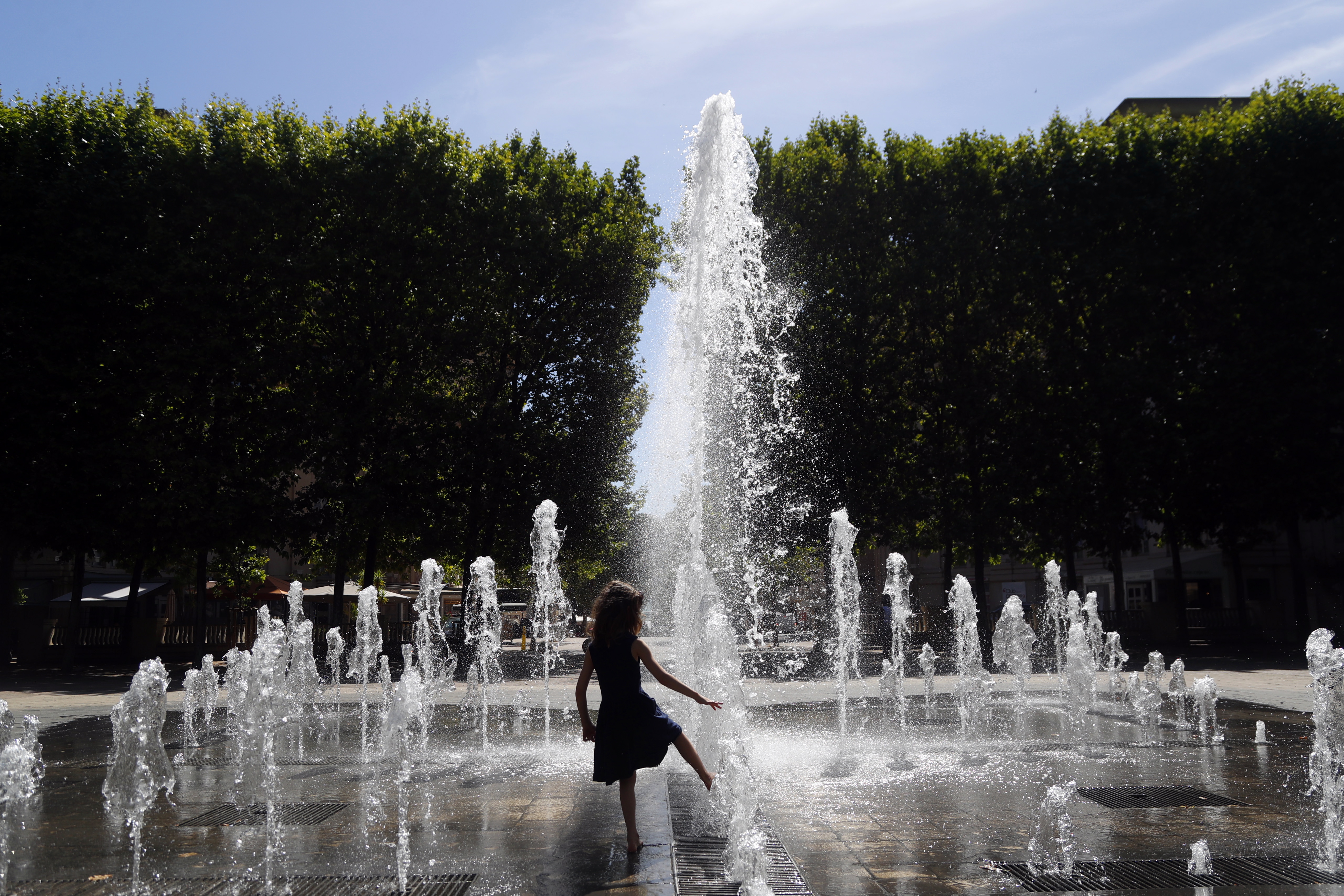 Una niña se refresca en una fuente pública de Montpellier, este martes.