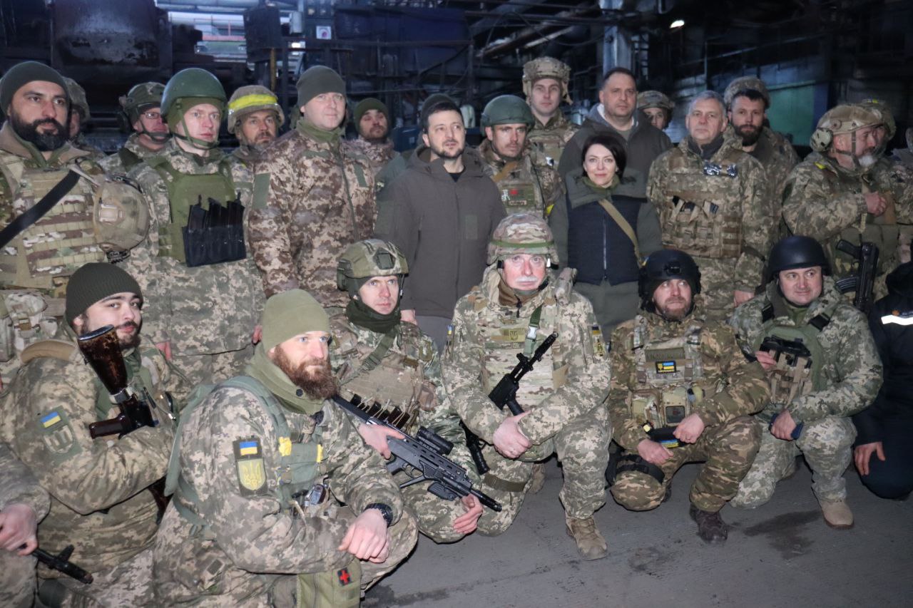 Gen, canto inferior esquerdo, com seu rifle voltado para a câmera, durante a visita de Zelensky (centro) a Bakhmut em 20 de dezembro.