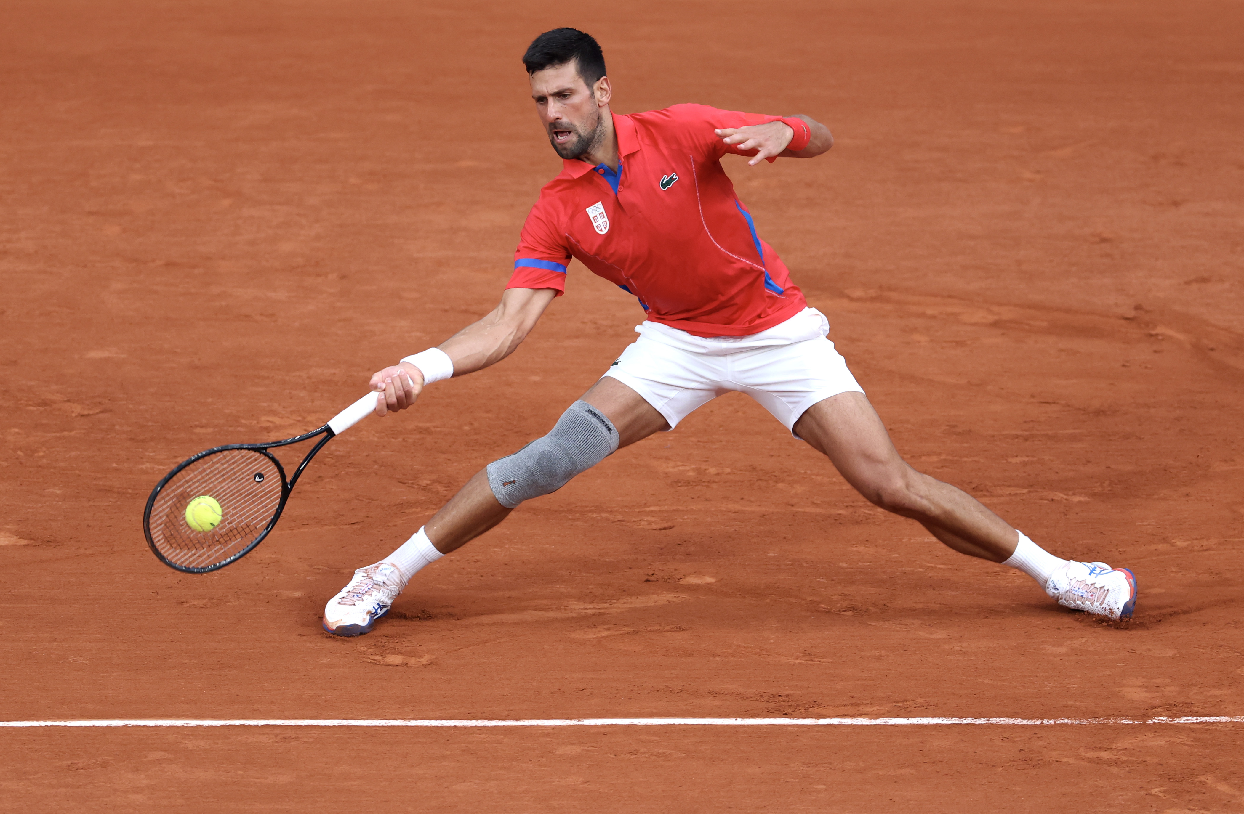 PARIS, FRANCE - AUGUST 01: Novak Djokovic of Team Serbia plays a forehand against Stefanos Tsitsipas of Team Greece during the Men's Singles Quarter-final match on day six of the Olympic Games Paris 2024 at Roland Garros on August 01, 2024 in Paris, France. (Photo by Matthew Stockman/Getty Images)