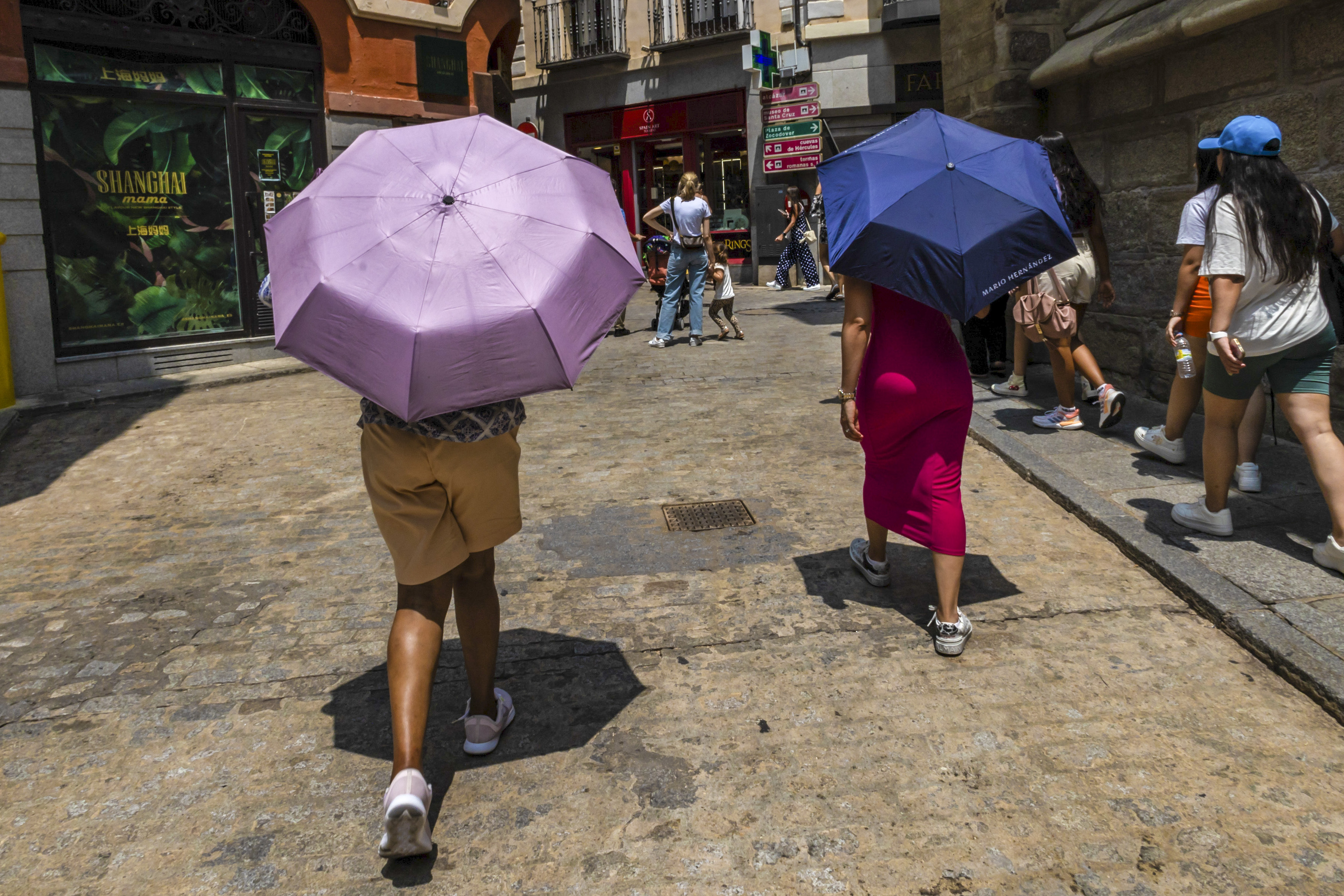 Varias personas se protegen del calor el martes con paraguas en Toledo. 