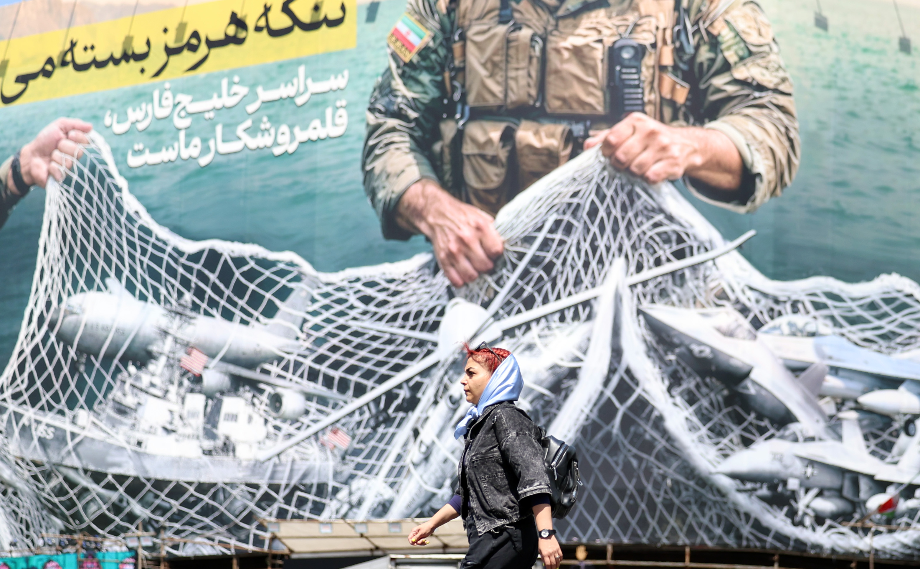 TEHRAN (IRAN(Islamic Republic Of)), 28/04/2026.- Iranians walk past a huge billboard carrying a sentence reading in Persian 'The Strait of Hormuz remains closed' at Enghelab Square in Tehran, Iran, 28 April 2026. US President Donald Trump announced that a ceasefire between the US and Iran has been extended. (Teherán) EFE/EPA/ABEDIN TAHERKENAREH
