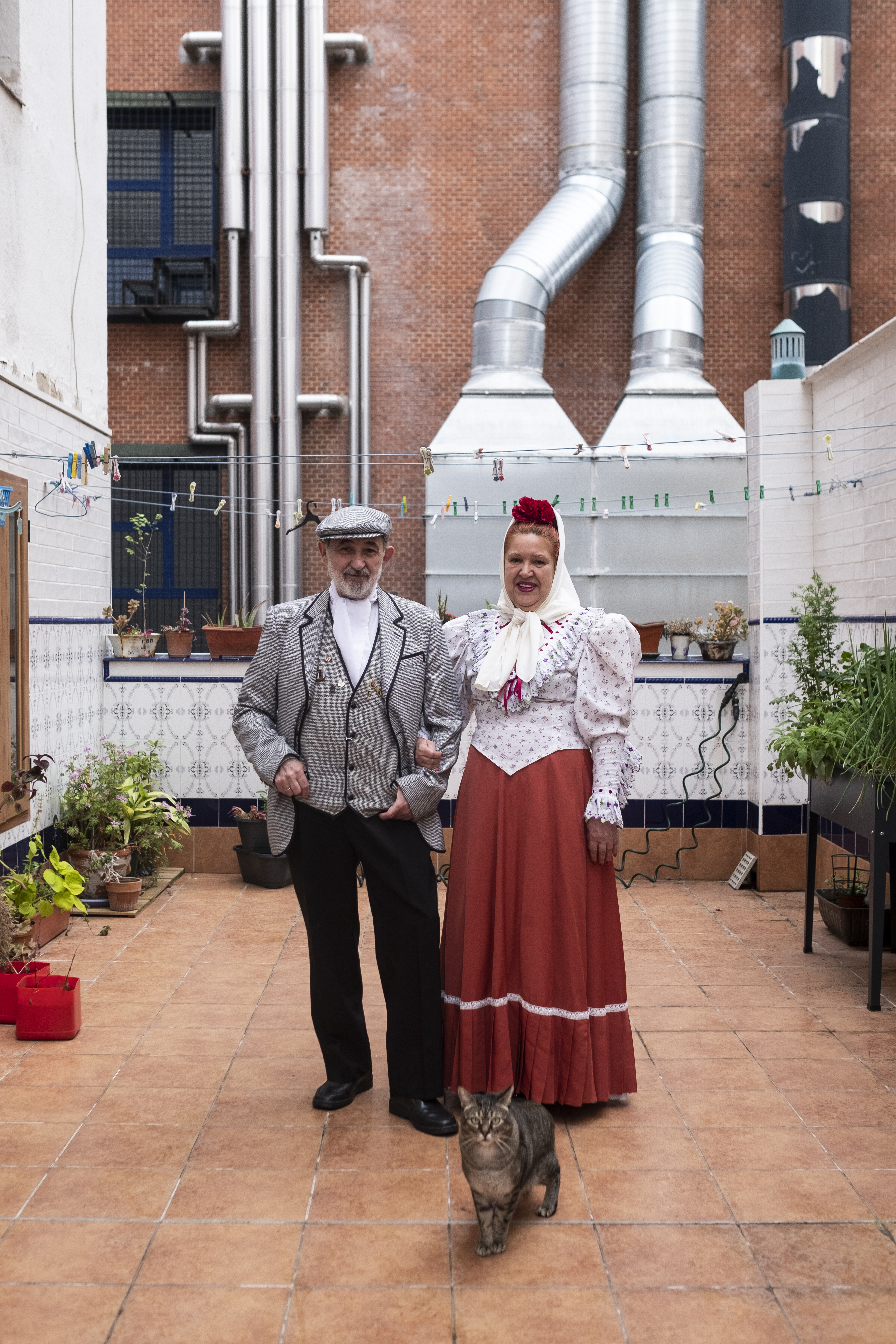 María Dolores Álvarez y José Luis Campos, vestidos de chulapos en el patio de su casa desde el que amenizan a sus vecinos.