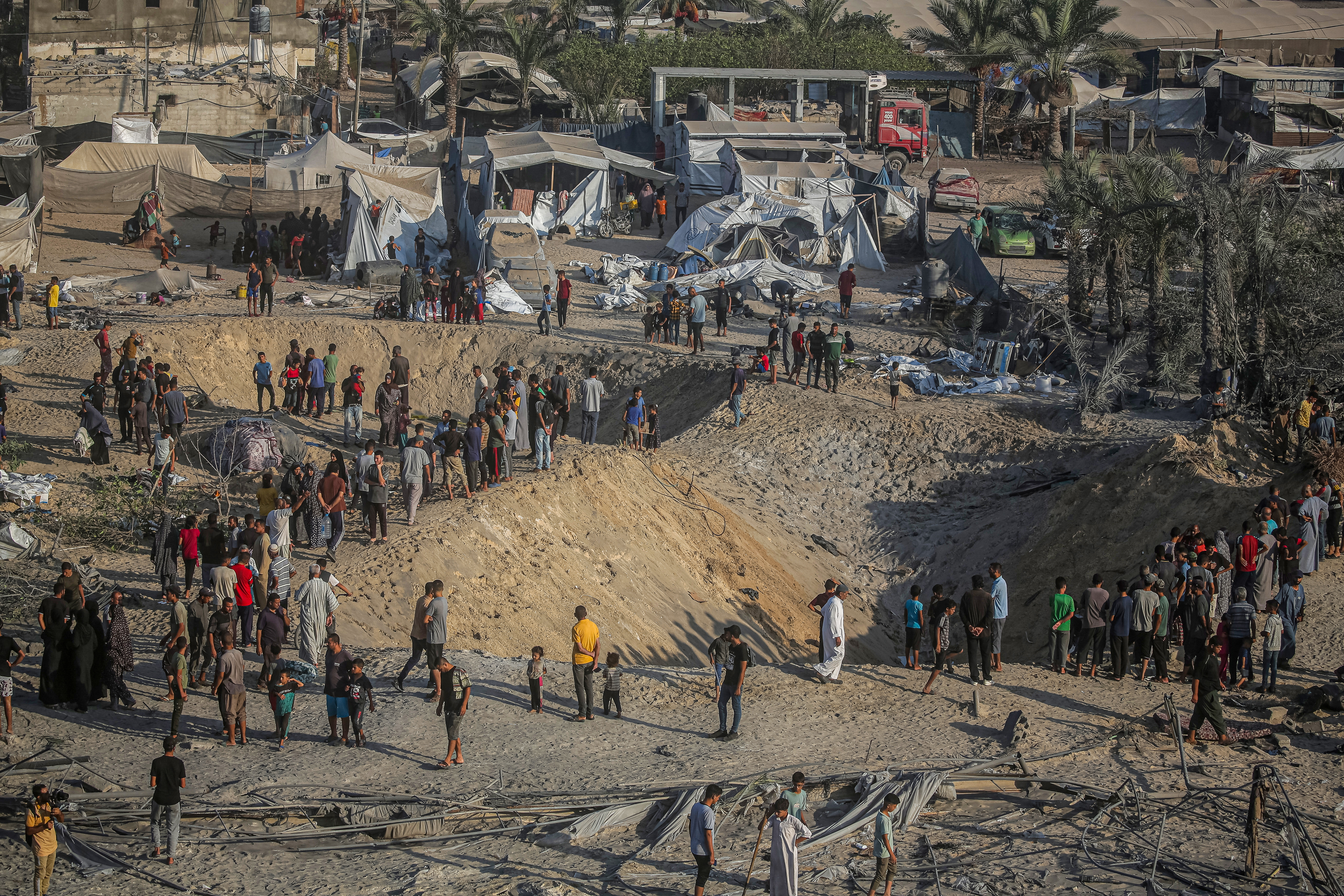 KHAN YUNIS, GAZA - SEPTEMBER 10: Palestinians are seen around the 9-meter-deep hole that formed in the area after Israeli airstrikes on a tent encampment Khan Yunis, Gaza on September 10, 2024. At least 40 Palestinians were killed and more than 60 injured early Tuesday in Israeli airstrikes on a tent encampment in Khan Younis in the southern Gaza Strip. Tents in the area were heavily damaged. (Photo by Jehad Alshrafi/Anadolu via Getty Images)