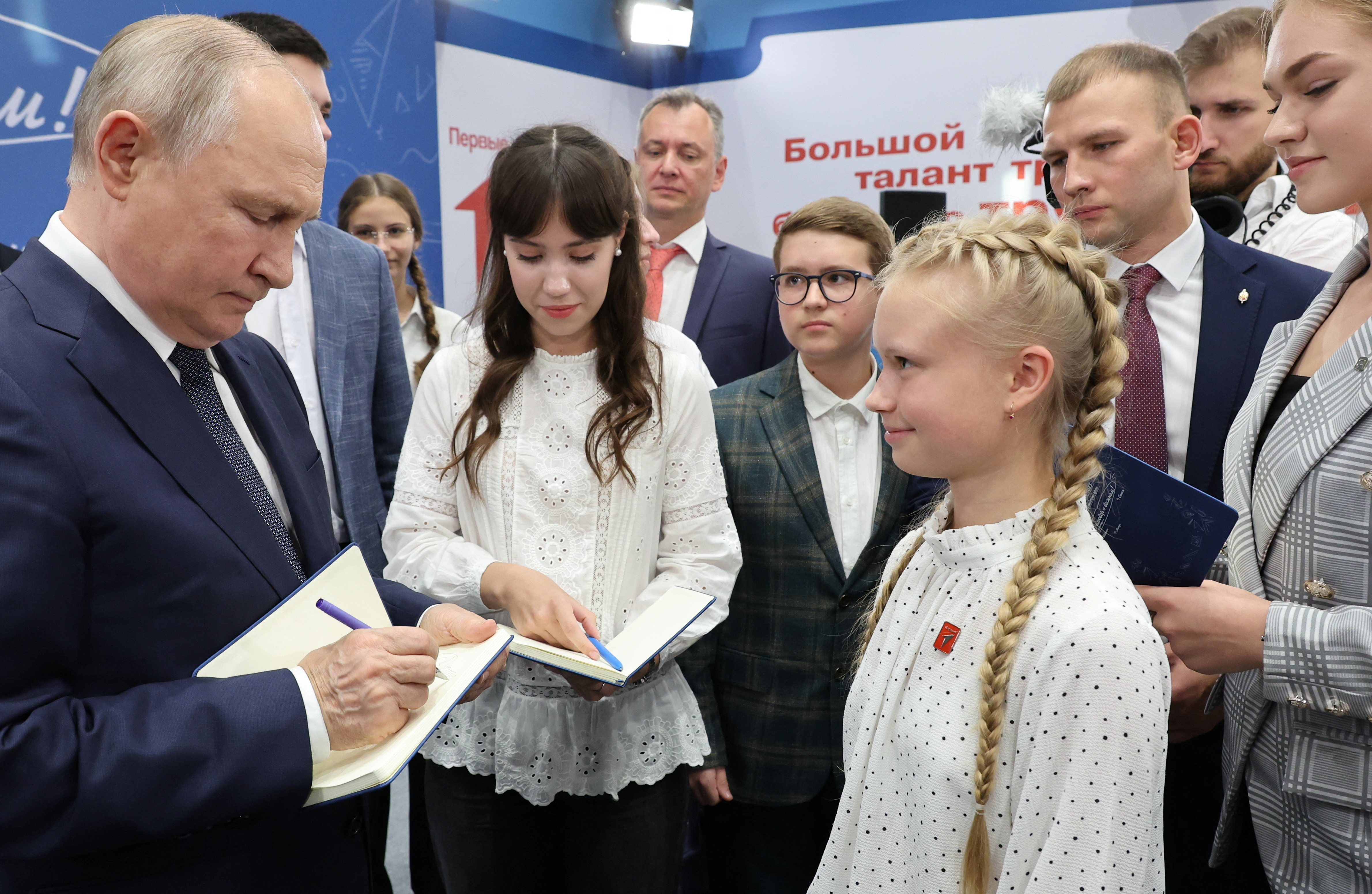 El presidente ruso, Vladímir Putin, firma autógrafos a escolares en un evento en Solnechnogorsk, en Moscú (Rusia), este viernes.