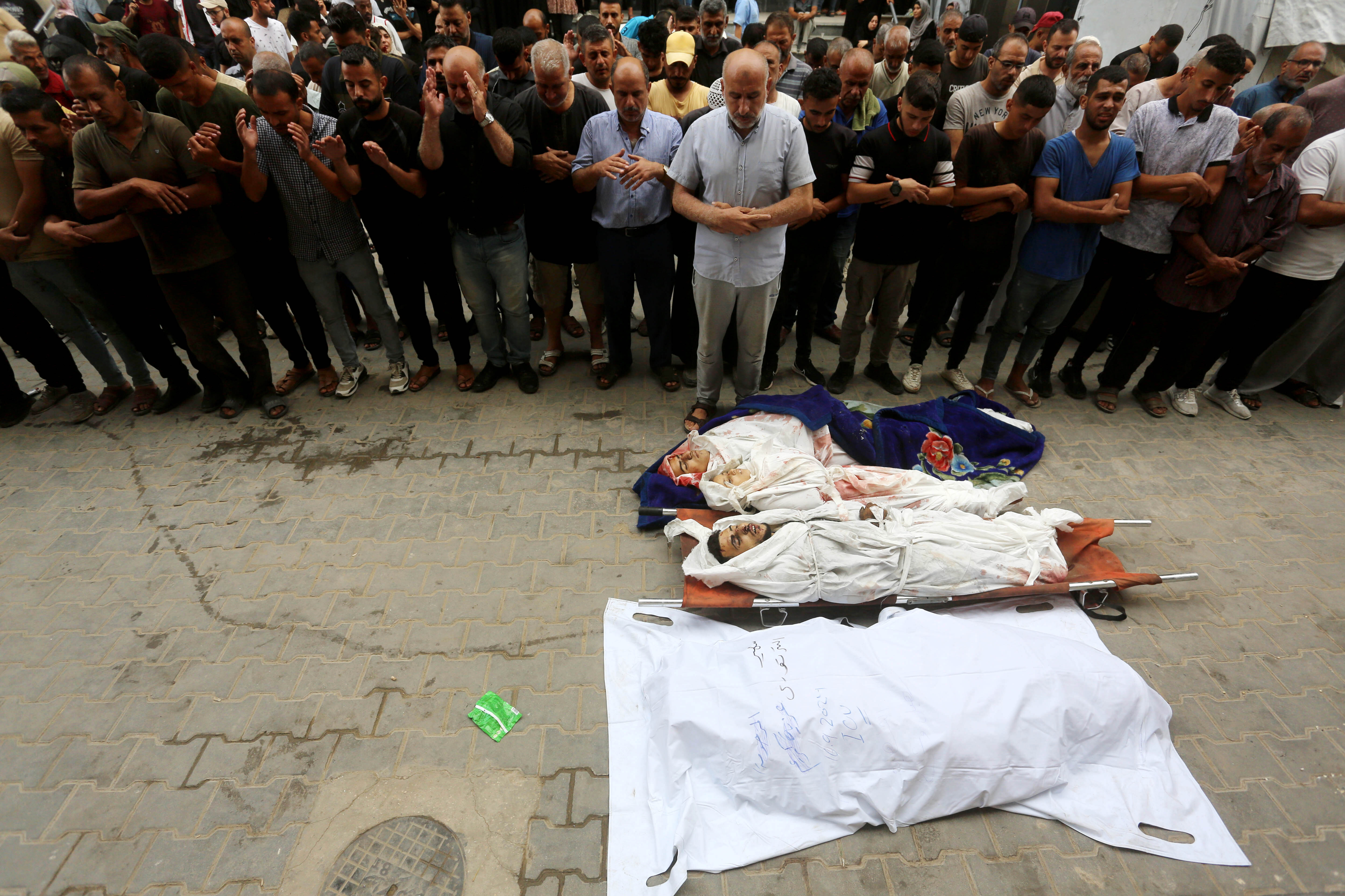 GAZA CITY, GAZA - SEPTEMBER 17: (EDITORS NOTE: Image depicts death) Palestinians who lost their relatives due to the Israeli attacks perform funeral prayer, at Al-Awda Hospital in northern Gaza on September 17, 2024. The Israeli army attacked a house belonging to the Al Tartory family in Nuseirat Refugee Camp in the central part of the Gaza Strip, killing and wounding Palestinians. The bodies of the Palestinians who lost their lives were taken from the morgue of Al-Awda Hospital in the city and sent to their last journeys. (Photo by Ashraf Amra/Anadolu via Getty Images)