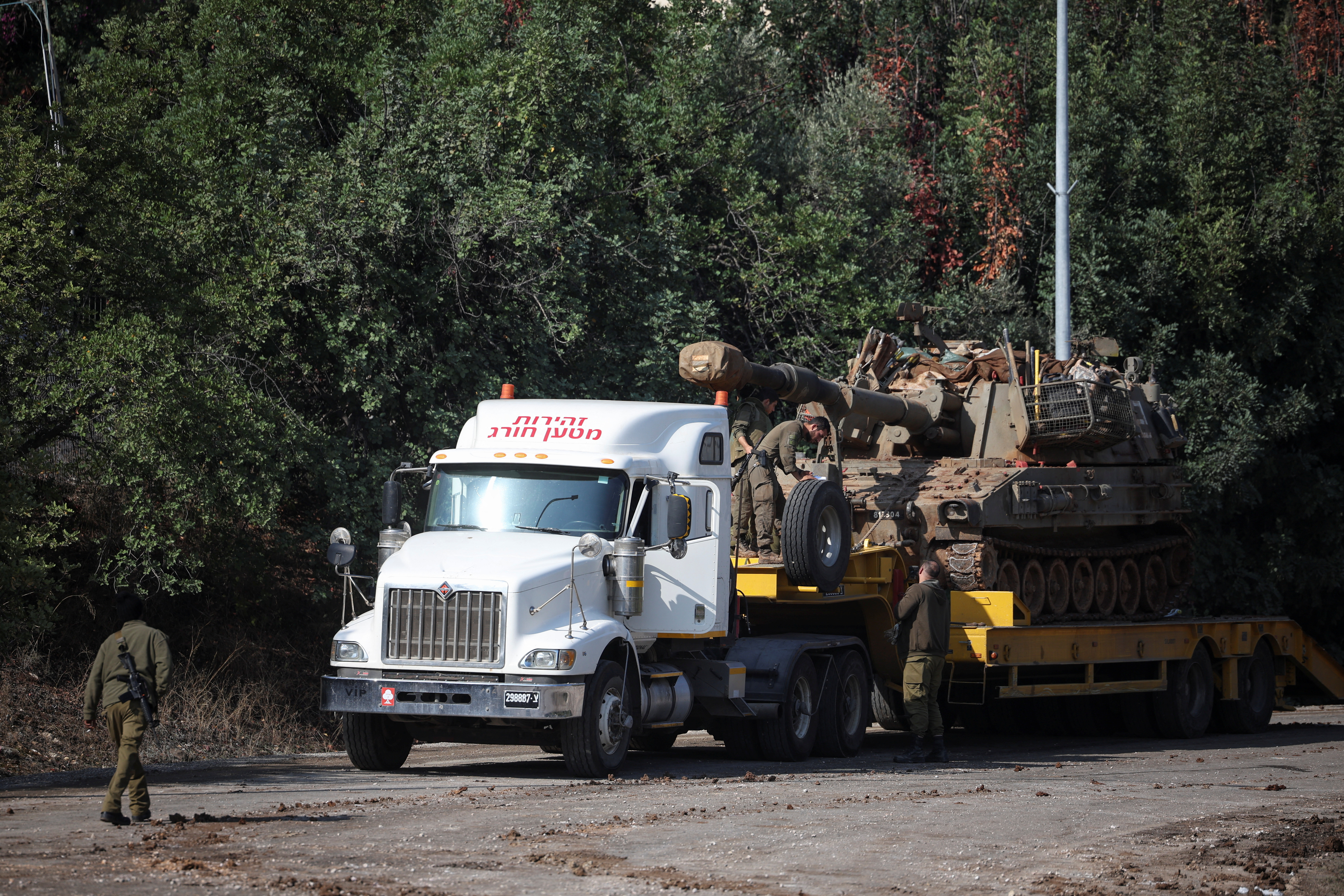 Soldados israelíes cargan a un vehículo militar sobre un camión durante el segundo día del alto el fuego entre Israel y Hezbolá en una carretera cercana a la frontera entre Líbano e Israel, este jueves 28 de noviembre