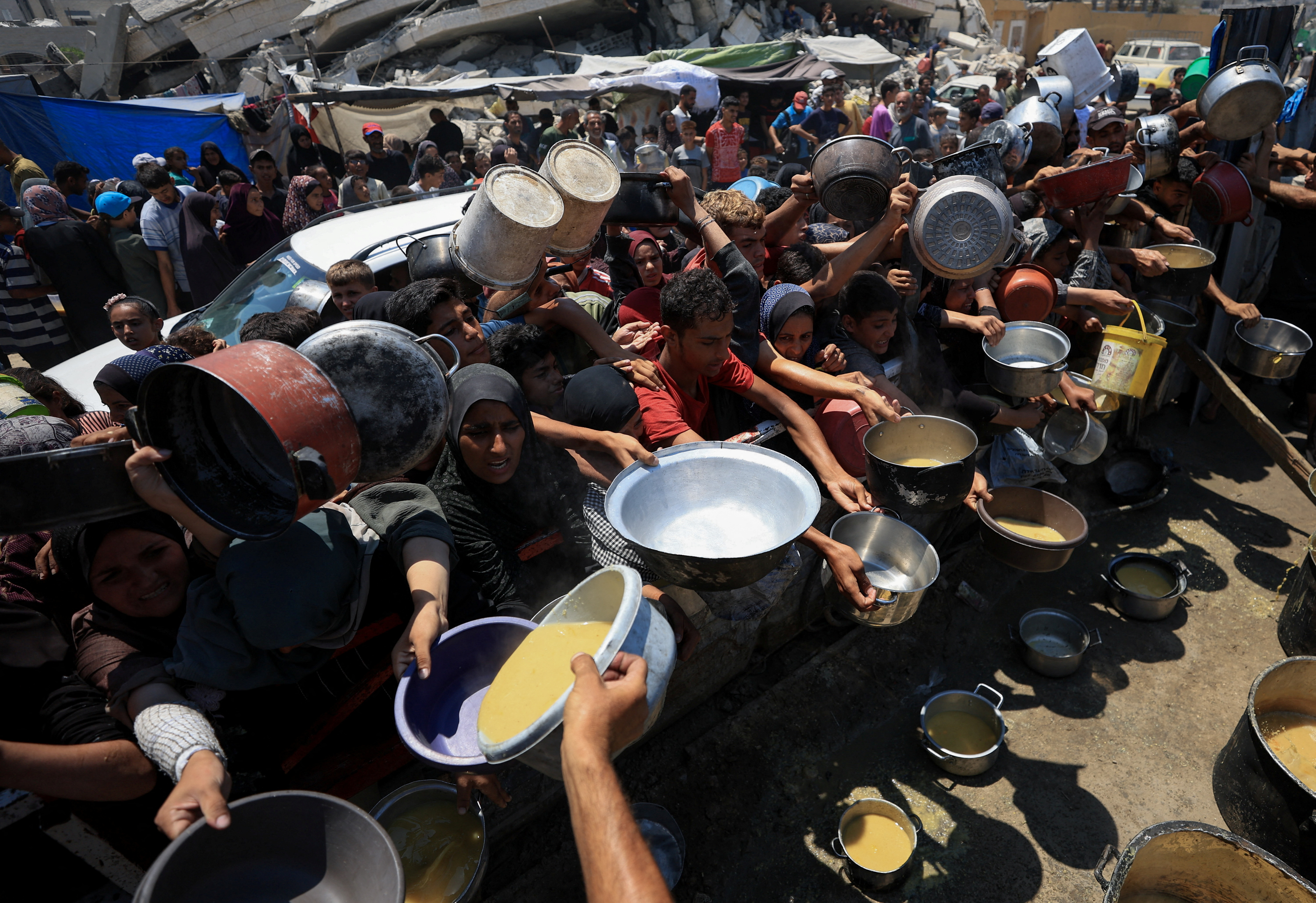 Palestinians gather to receive food from a charity kitchen, amid a hunger crisis, in Gaza City, July 25, 2025. REUTERS/Dawoud Abu Alkas