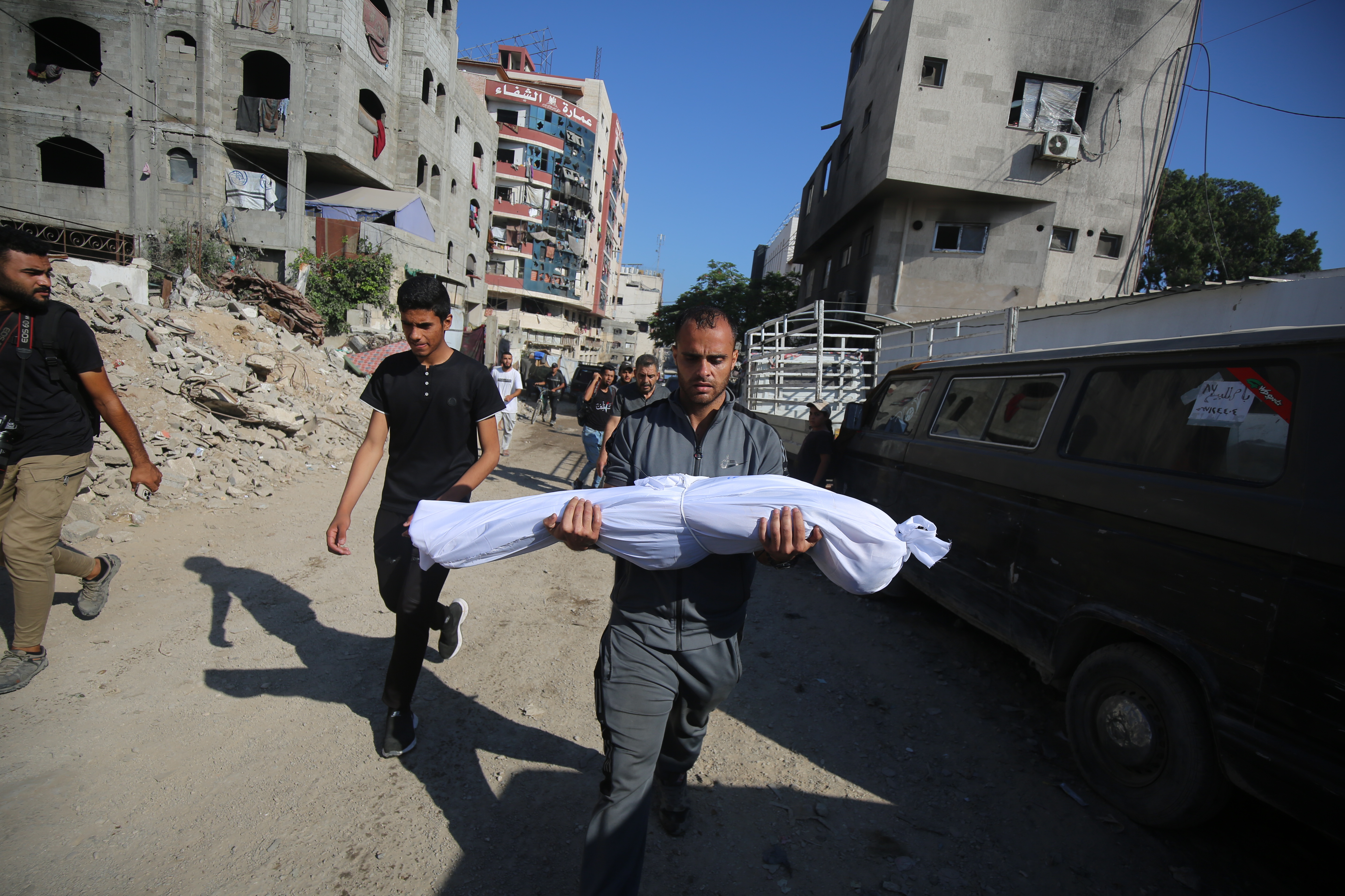 Un hombre carga este miércoles el cadáver de un niño muerto por un ataque israelí contra tiendas de desplazados en Ciudad de Gaza.