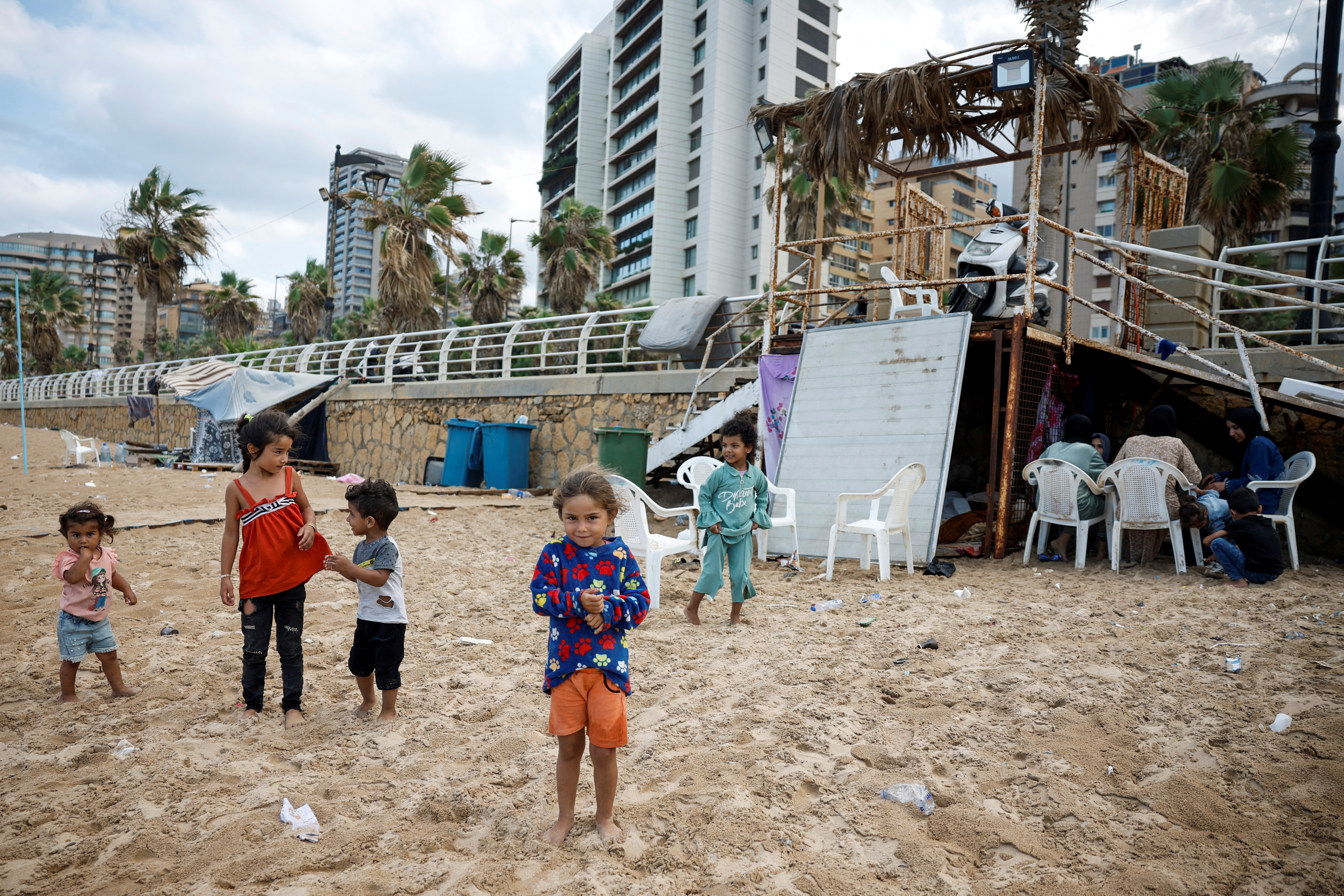 Niños desplazados se paran enfrente de un campamento hechizo en la playa de Beirut, a donde han llegado por los bombardeos de Israel sobre la capital libanesa, este 1 de octubre.