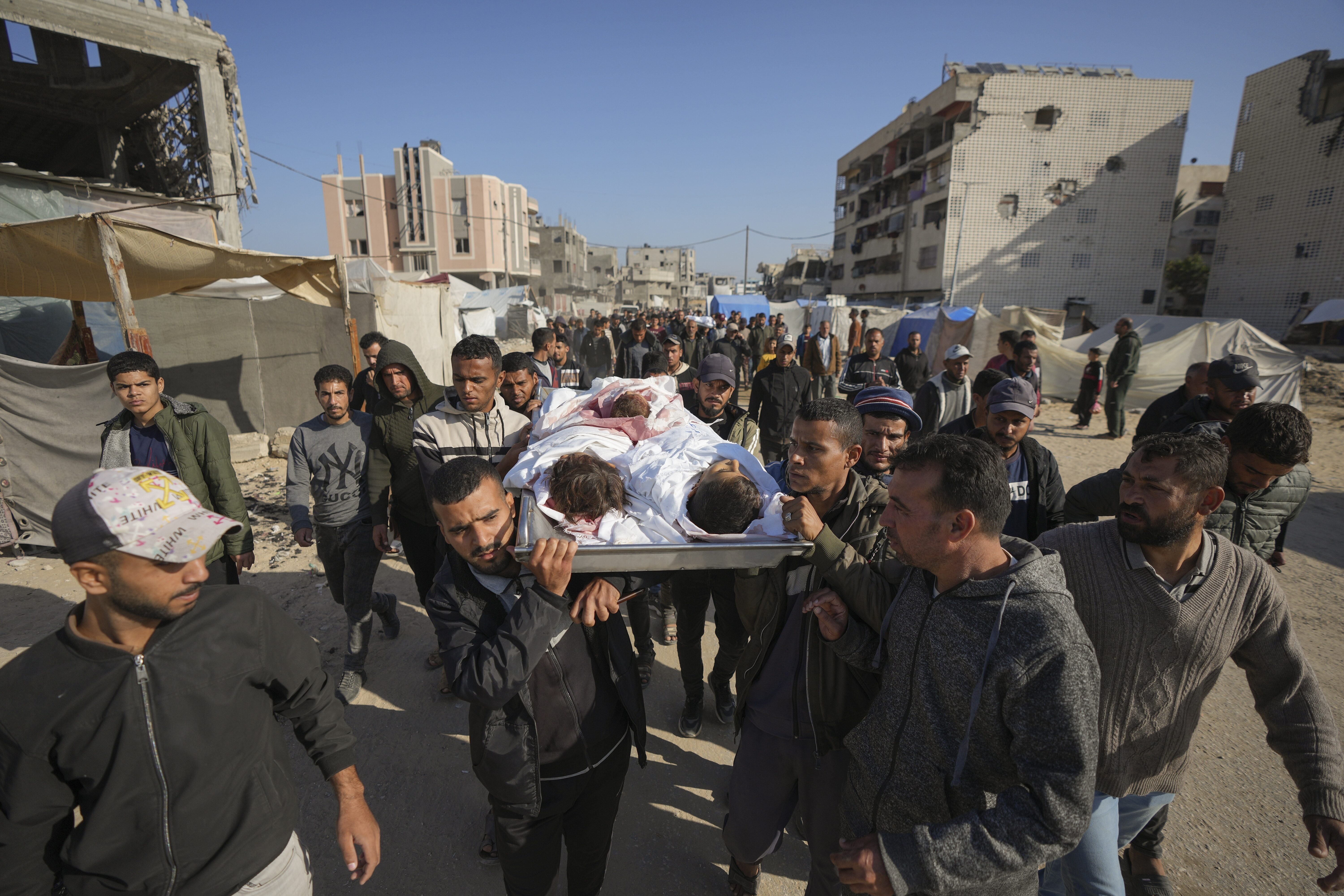 Los cuerpos de tres menores, víctimas mortales de un ataque israelí este miércoles en Jan Yunis, en el sur de Gaza,  son trasladados a un cementerio en Deir al-Balah, en el centro de la Franja, este jueves 21 de noviembre