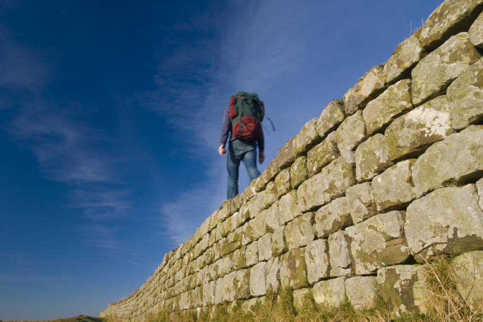Una persona camina por la  Muralla de Adriano.