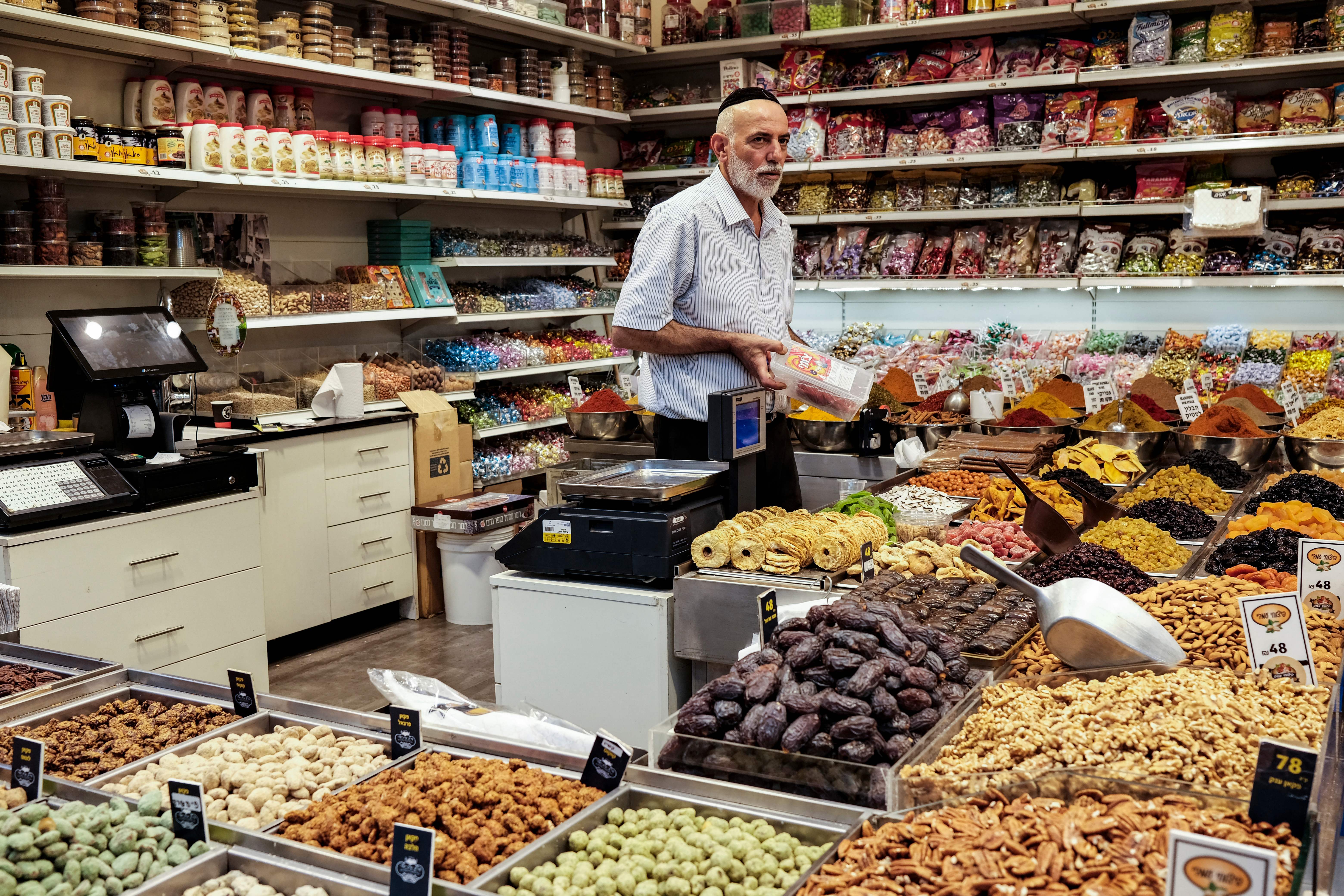 An Israeli man sells groceries at the Mahane Yehuda market in Jerusalem, on August 25, 2022. (Photo by RONALDO SCHEMIDT / AFP) (Photo by RONALDO SCHEMIDT/AFP via Getty Images)