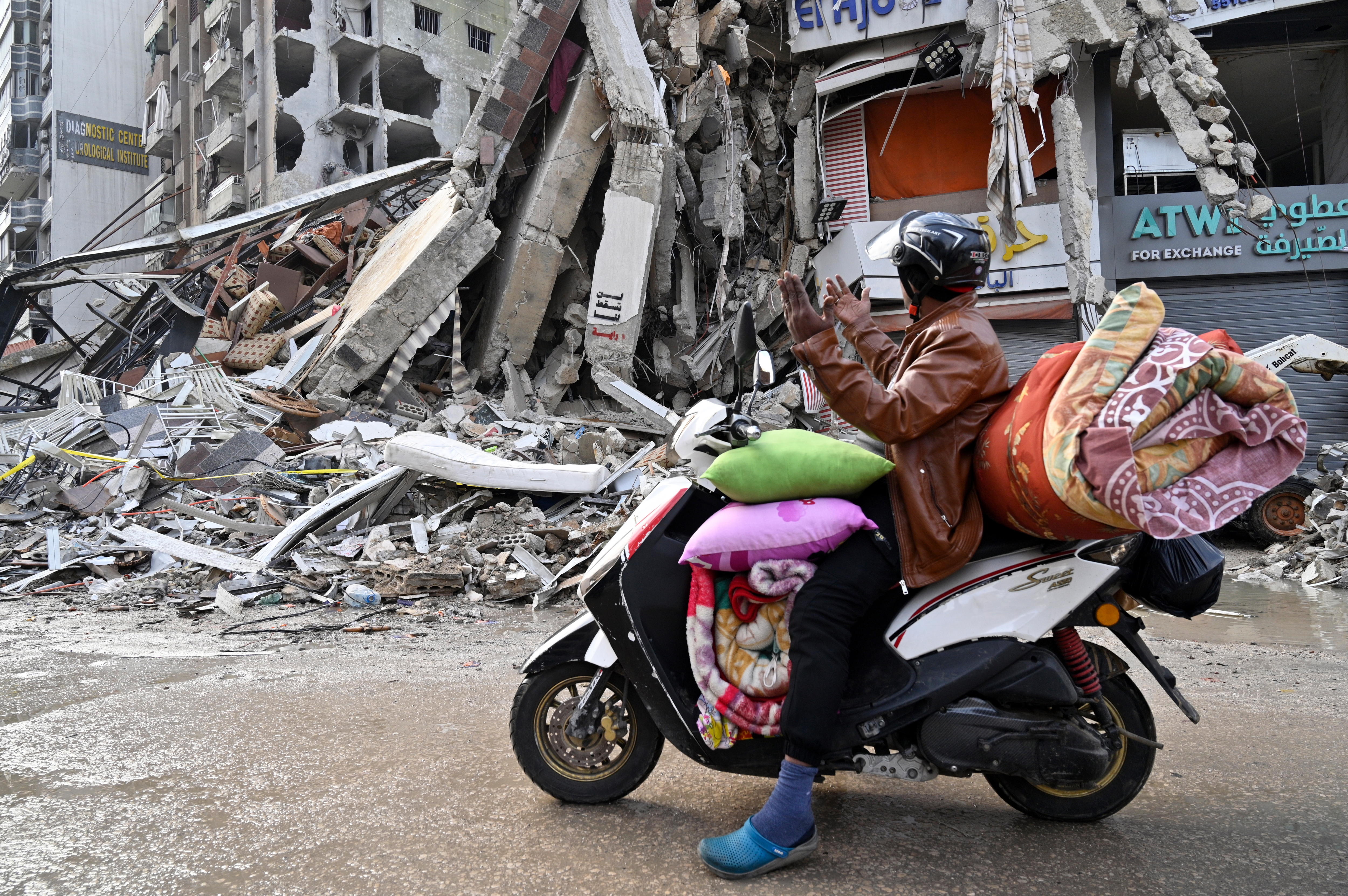 Un hombre sobre una motocicleta mira los escombros de un edificio en el suburbio de Dahiye, en el sur de Beirut, Líbano, este viernes 29 de noviembre