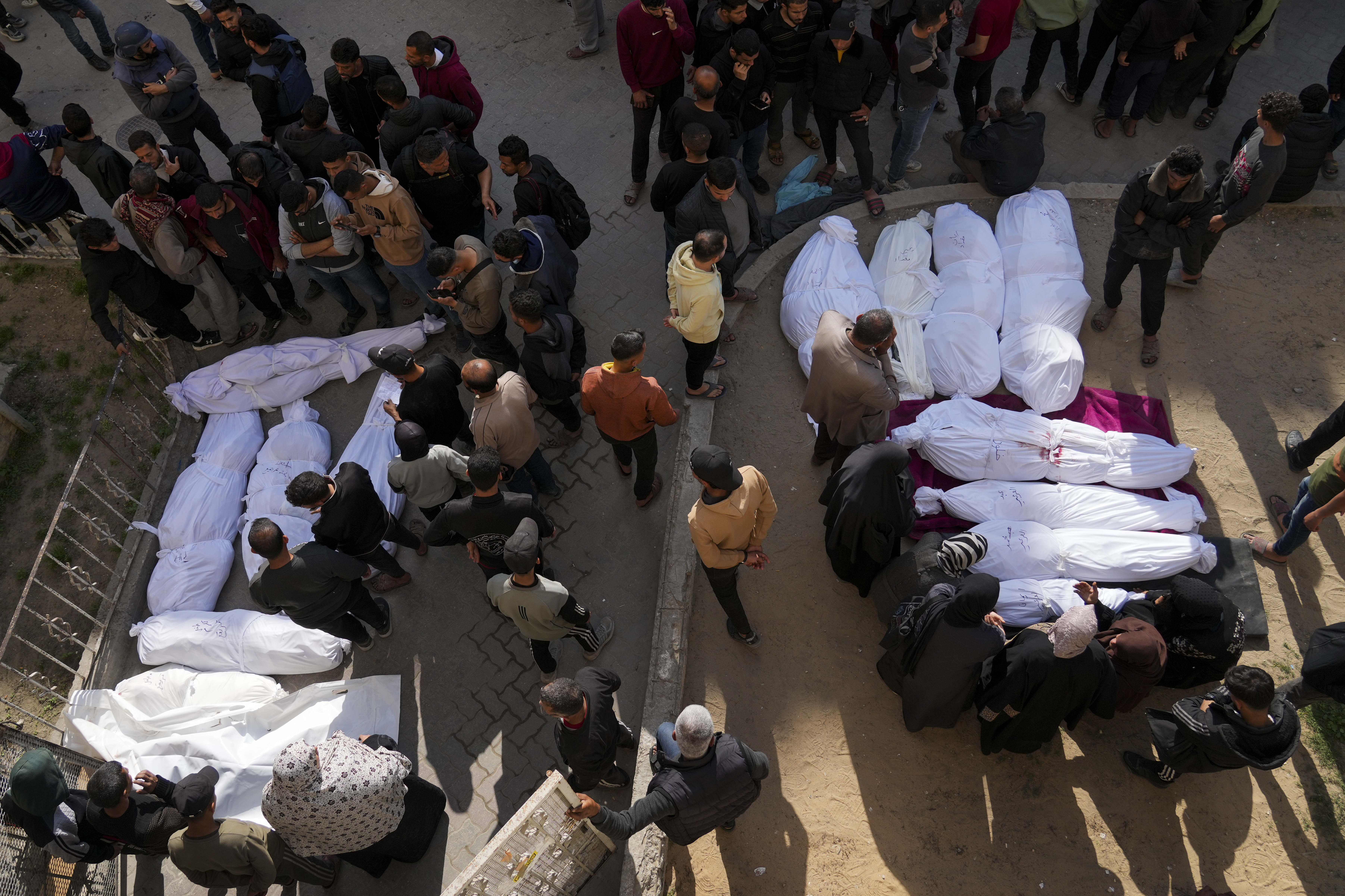 Mourners gather around the bodies of Palestinians who were killed in an Israeli army airstrikes as they are brought to Al-Ahli Hospital in Gaza City, Tuesday, March 18, 2025. (AP Photo/Abdel Kareem Hana)