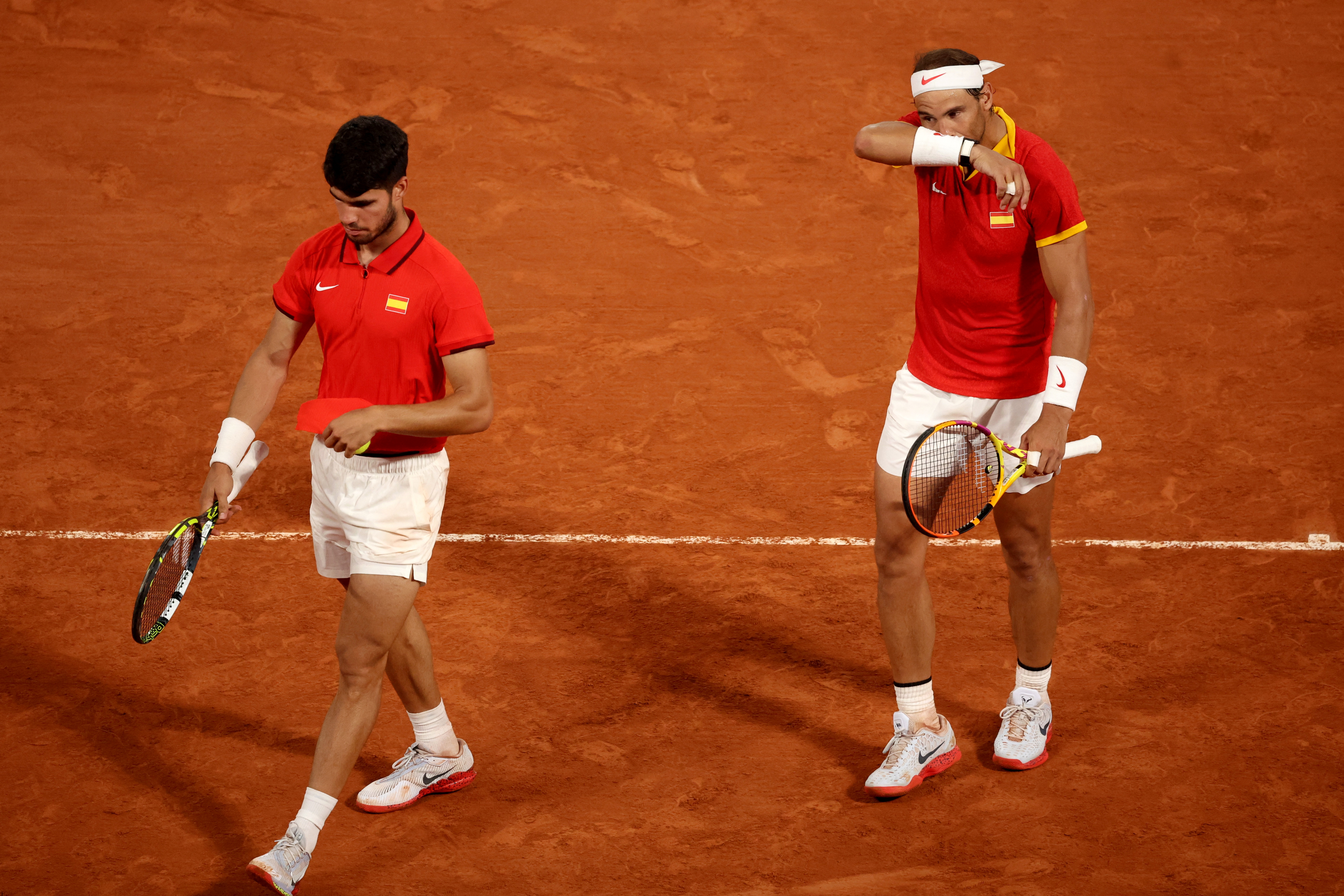 Paris 2024 Olympics - Tennis - Men's Doubles Quarterfinals - Roland-Garros Stadium, Paris, France - July 31, 2024. Carlos Alcaraz of Spain and Rafael Nadal of Spain react during their match against Austin Krajicek of United States and Rajeev Ram of United States. REUTERS/Phil Noble