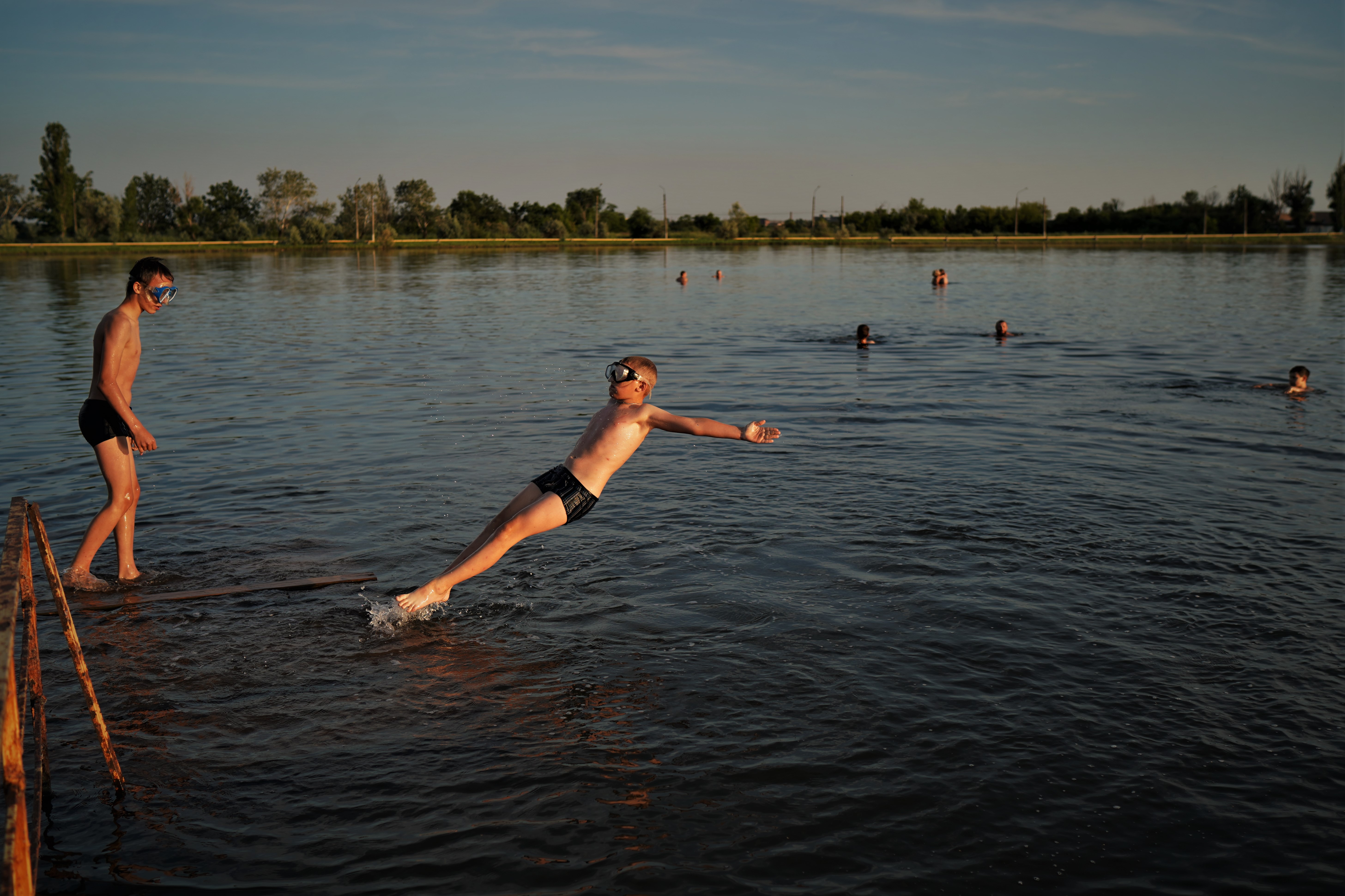 Algumas crianças tomam banho no lago Sloviansk.