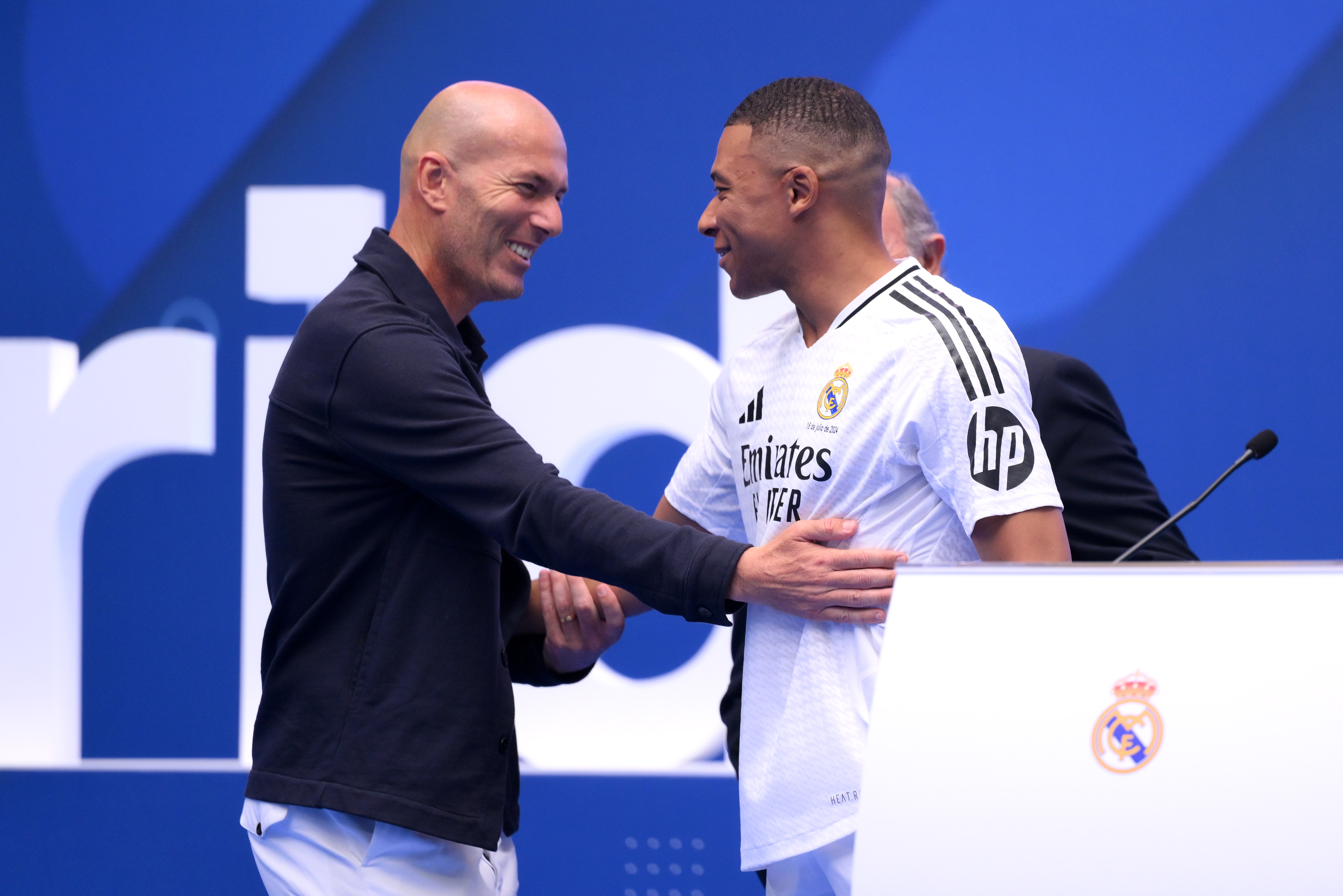 MADRID, SPAIN - JULY 16: Real Madrid new signing, Kylian Mbappe (R) is greeted by former Real Madrid player and coach, Zinedine Zidane as he is unveiled at Estadio Santiago Bernabeu on July 16, 2024 in Madrid, Spain. (Photo by David Ramos/Getty Images)