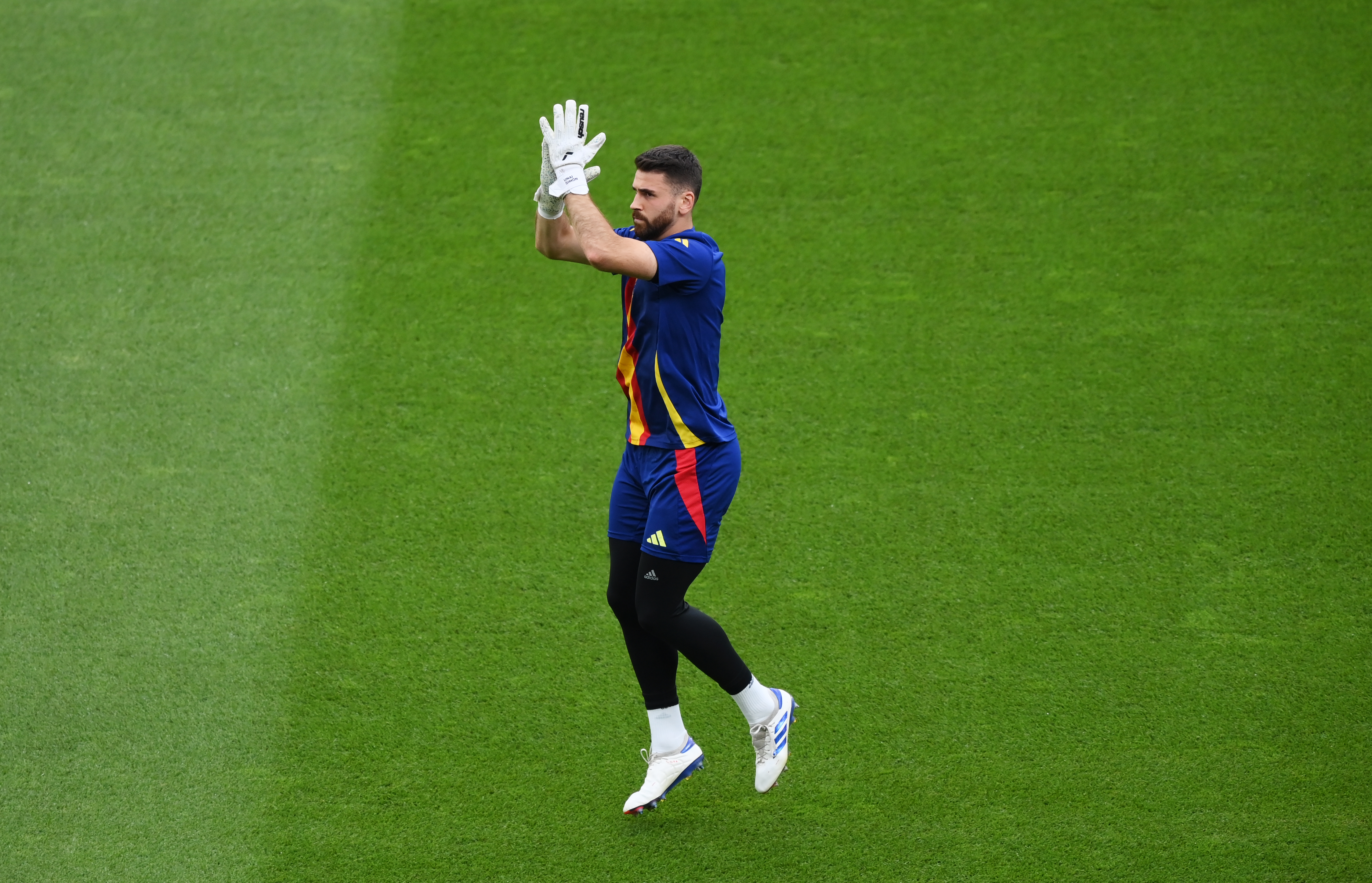 BERLIN, GERMANY - JULY 14: Unai Simon of Spain acknowledges the fans as he warms up prior to the UEFA EURO 2024 final match between Spain and England at Olympiastadion on July 14, 2024 in Berlin, Germany. (Photo by Justin Setterfield/Getty Images)