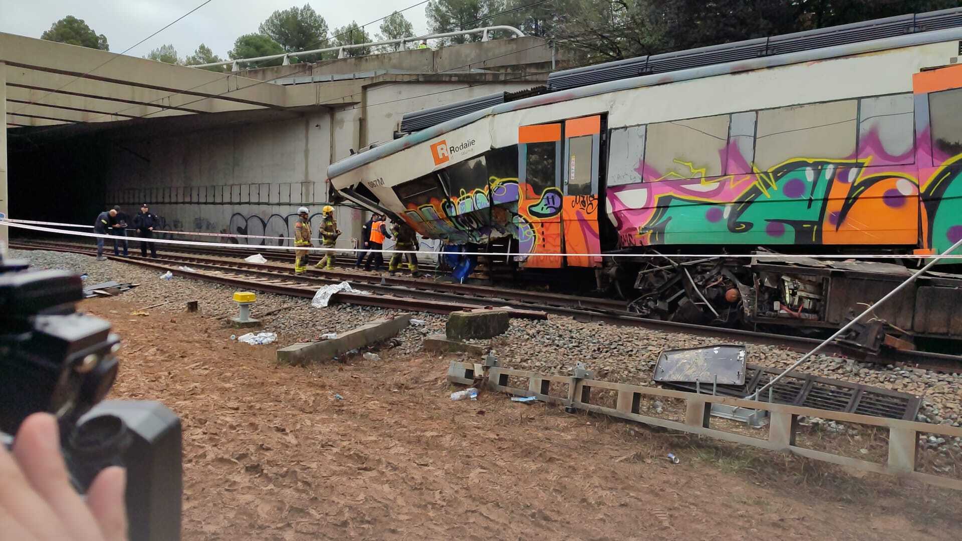 Los bomberos trabajan en el lugar del accidente del tren de Rodalies que chocó contra un muro de contención que había caído a la vía entre Gelida y Sant Sadurní d'Anoia (Barcelona).