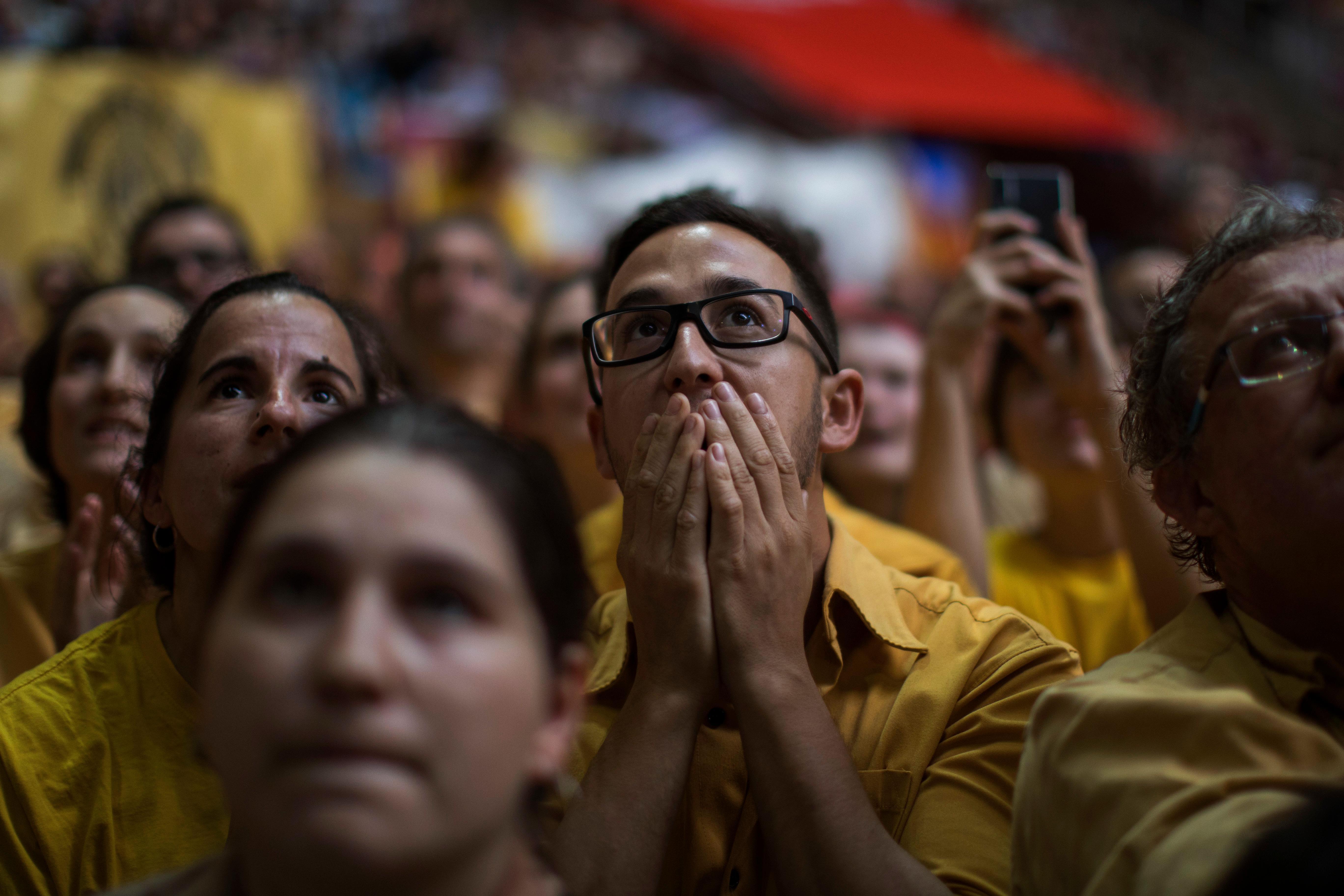 In this Saturday, Oct. 6, 2018 photo, a participant reacts as members of the "Nens de Vendrell" try to complete their human tower, during the 27th Human Tower Competition in Tarragona, Spain. The tradition of building human towers or "castells" dates back to the 18th century and takes place during festivals in Catalonia, where "colles" or teams compete to build the tallest and most complicated towers. "Castells" were declared by UNESCO one of the Masterpieces of the Oral and Intangible Heritage of Humanity. (AP Photo/Emilio Morenatti)