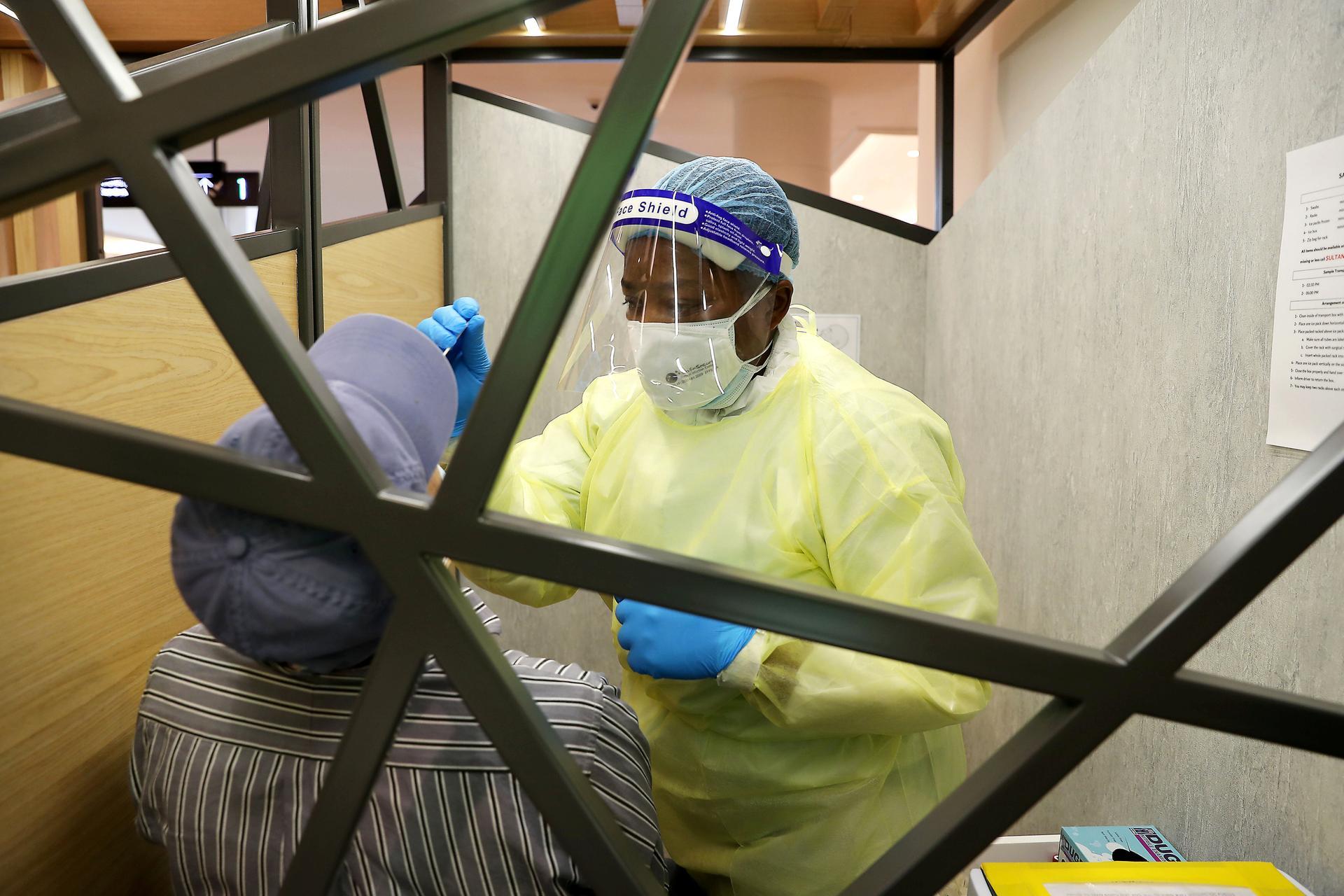 A health worker taking the Covid-19 nasal swab test at a testing station in thet Mall of the Emirates in Dubai. Pawan Singh / The National