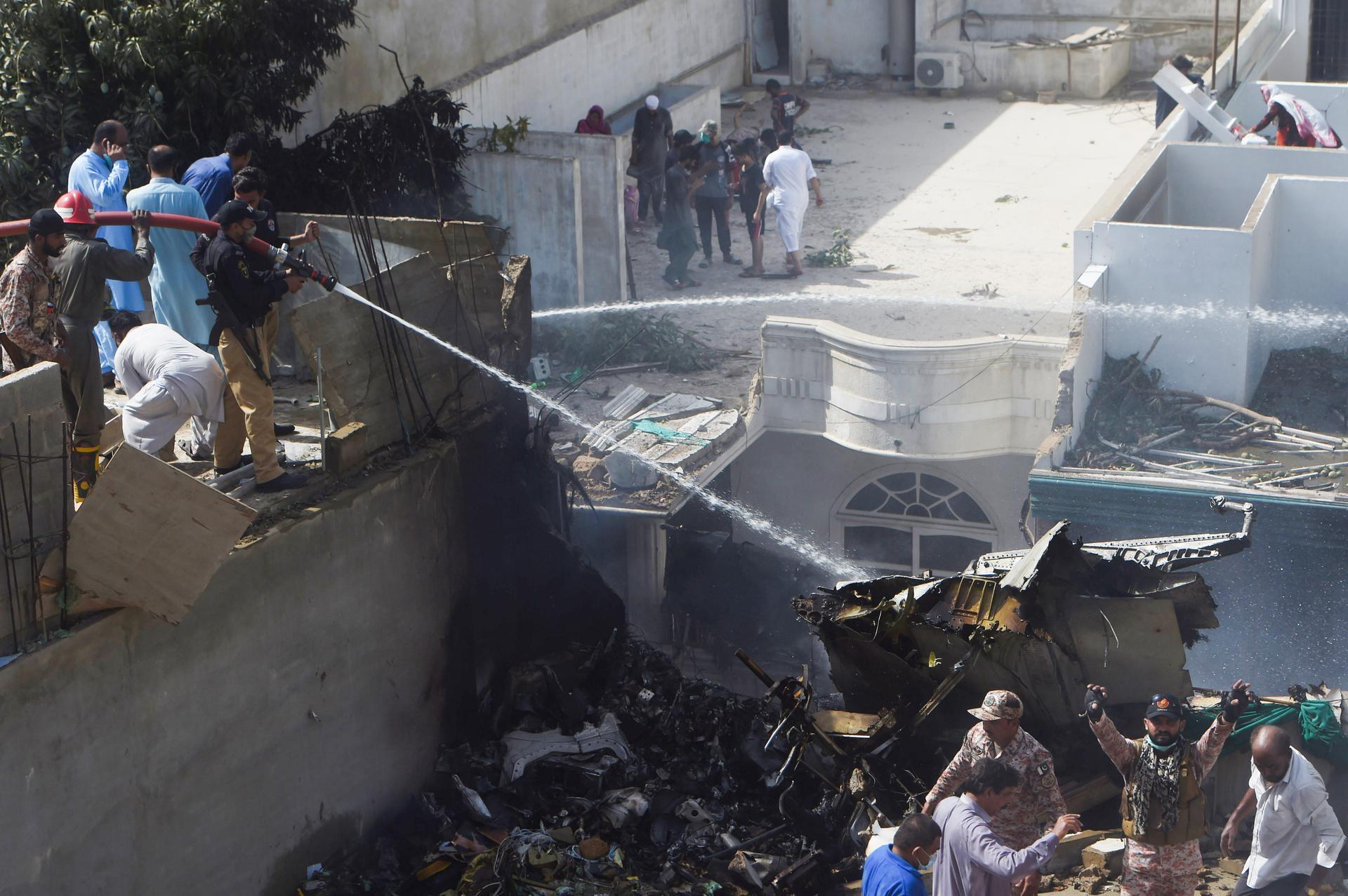 Policemen spray water on the part of a Pakistan International Airlines aircraft.