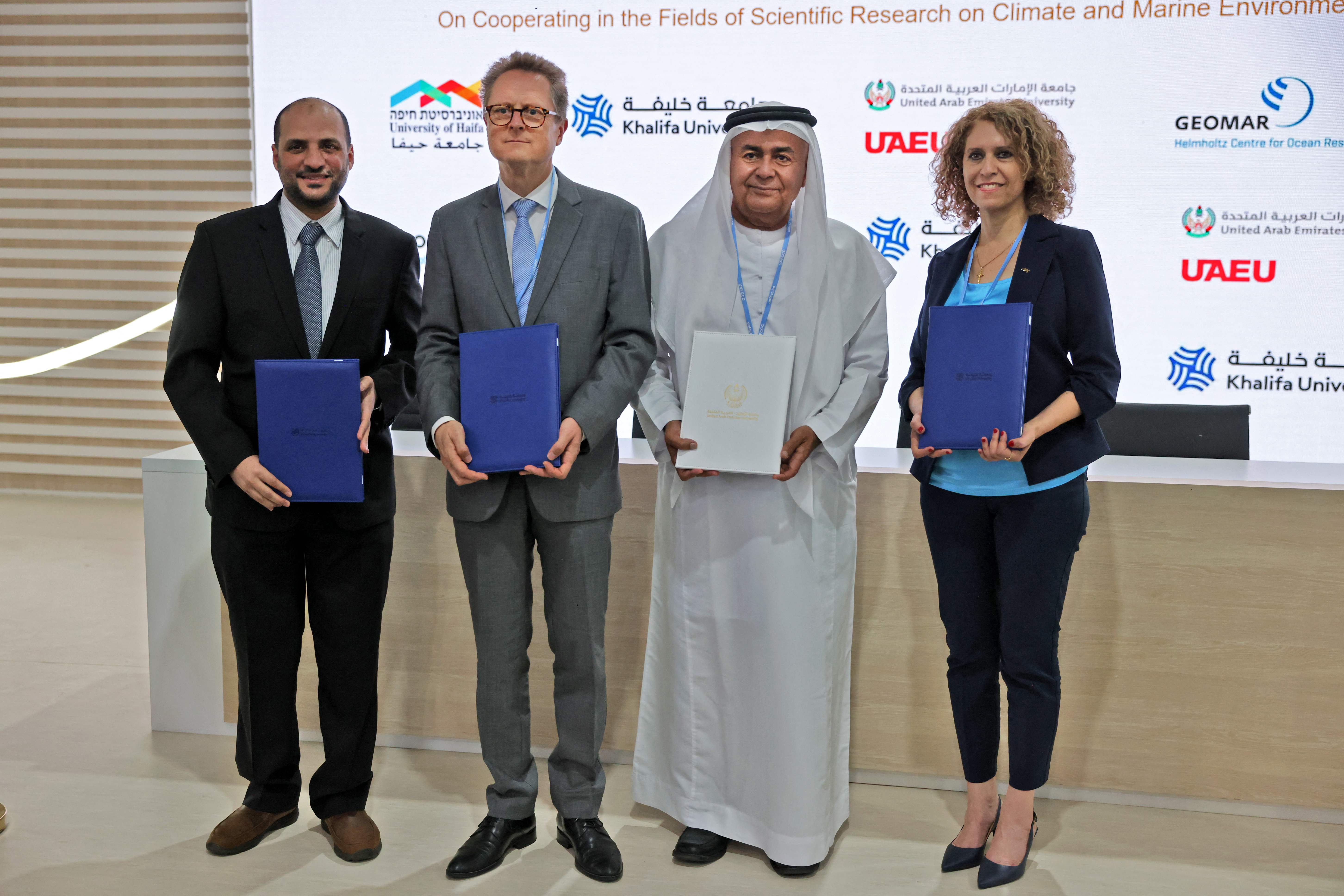 From left, Fahad Al Maskari of the Khalifa University, Frank Hartmann, Ghaleb Al Breiki of the UAE University, and Mouna Maroun of the University of Haifa, sign an agreement at Cop27. AFP