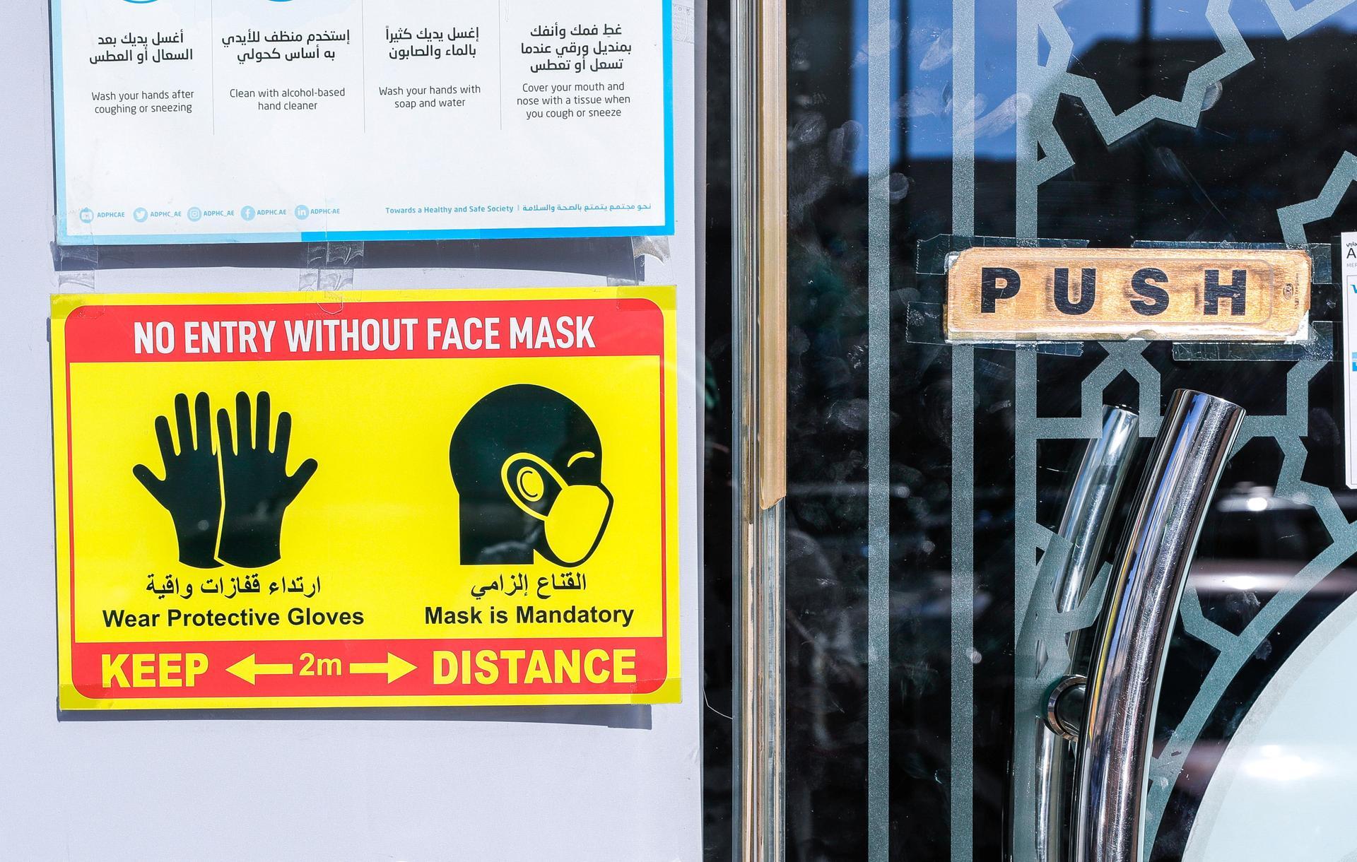 A Covid-19 safety sign outside a shop at Al Qahirah Street, Abu Dhabi. Victor Besa / The National