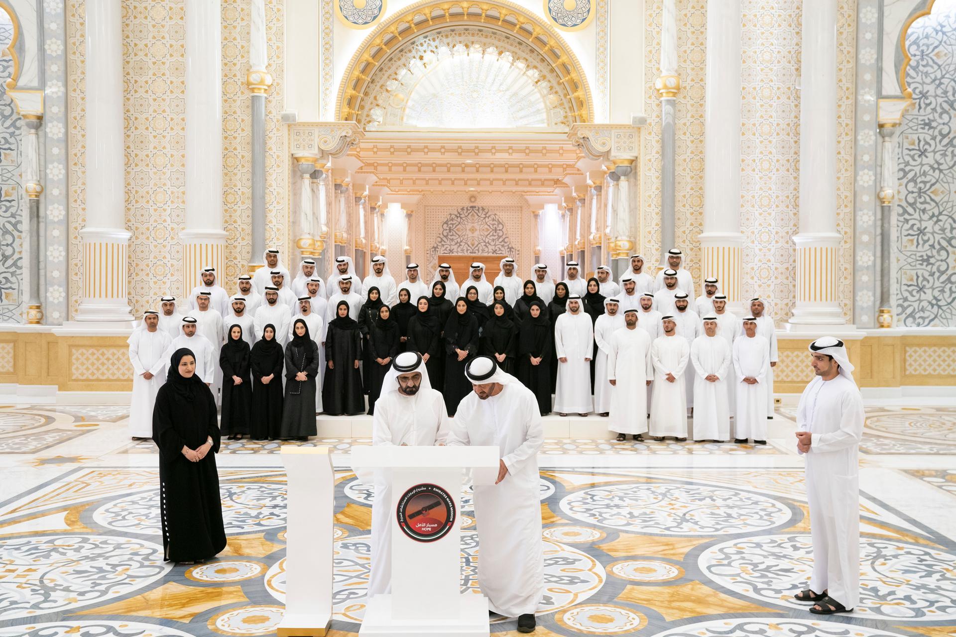 Sheikh Mohammed bin Rashid and Sheikh Mohamed bin Zayed sign a piece of the Hope Probe. Seen with Sarah Al Amiri, Minister of State for Advanced Sciences, front left. Hamad Al Kaabi / Ministry of Presidential Affairs