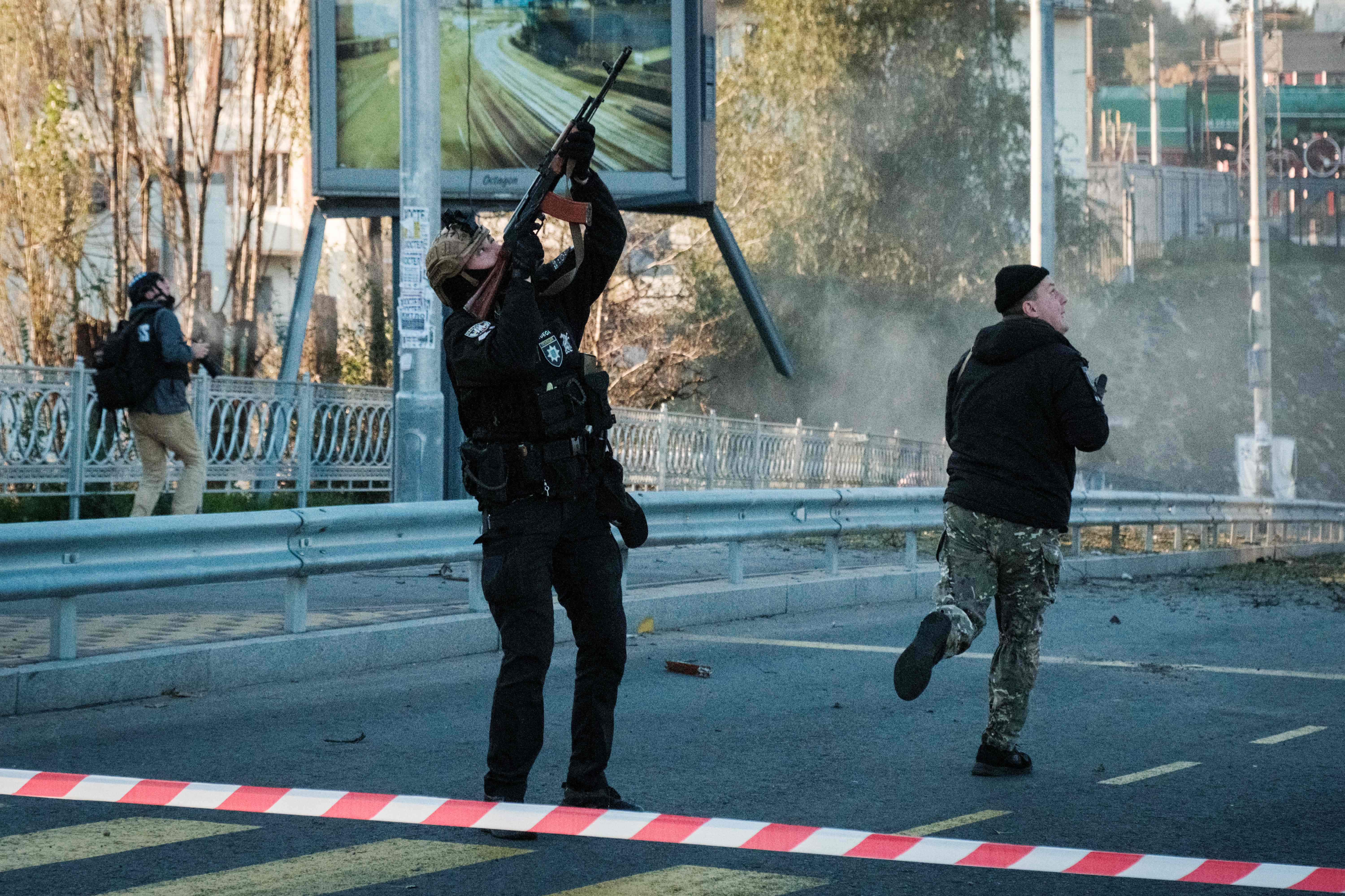 A police officer fires at a drone flying overhead. AFP