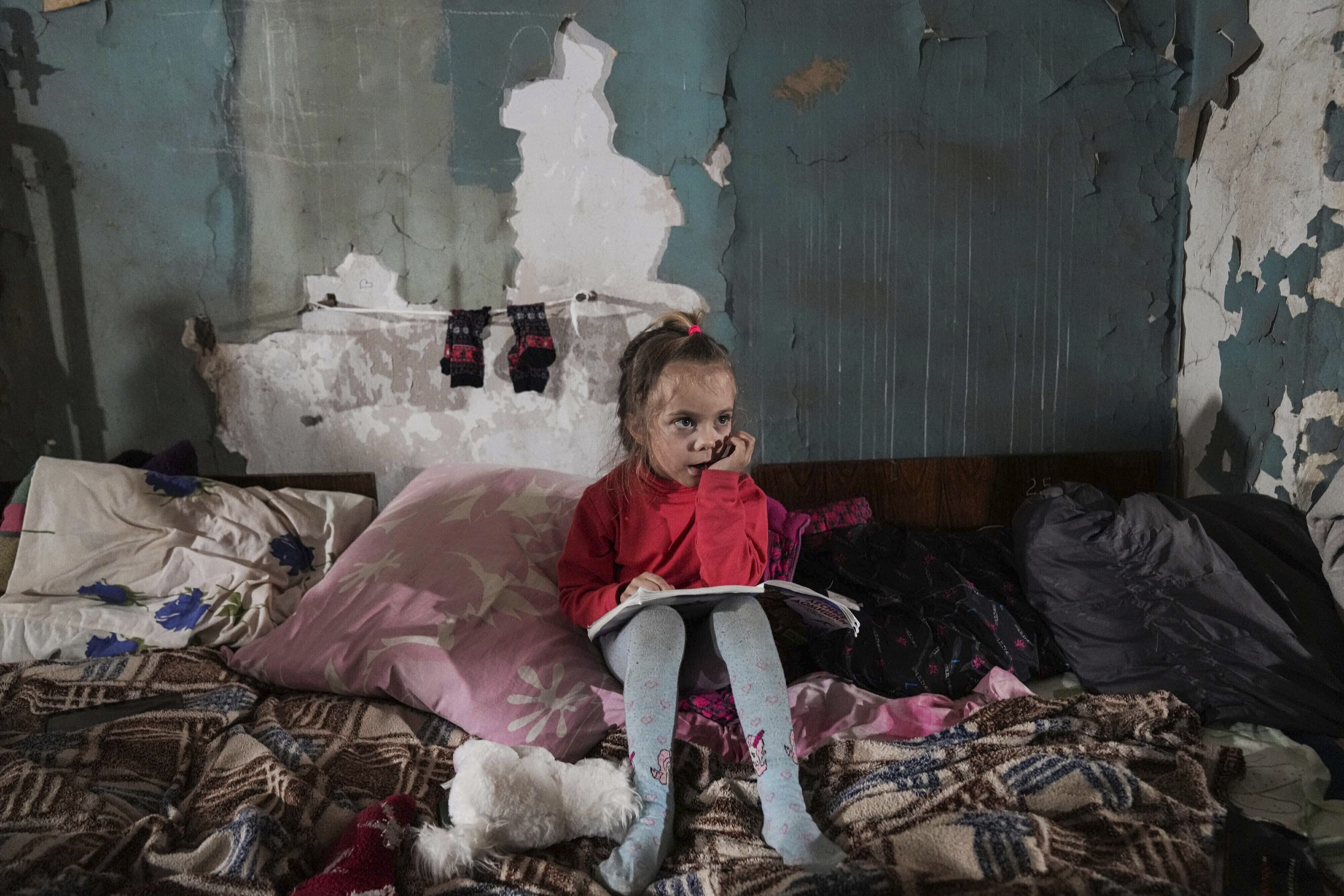 A girl sits in an improvised bomb shelter in Mariupol, Ukraine. AP