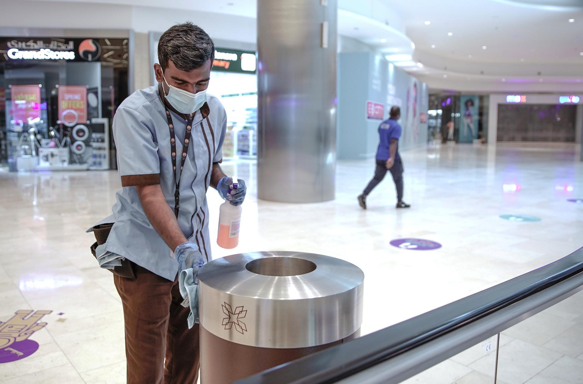 Cleaners disinfect rubbish bins and handrails at Yas Mall. Victor Besa / The National