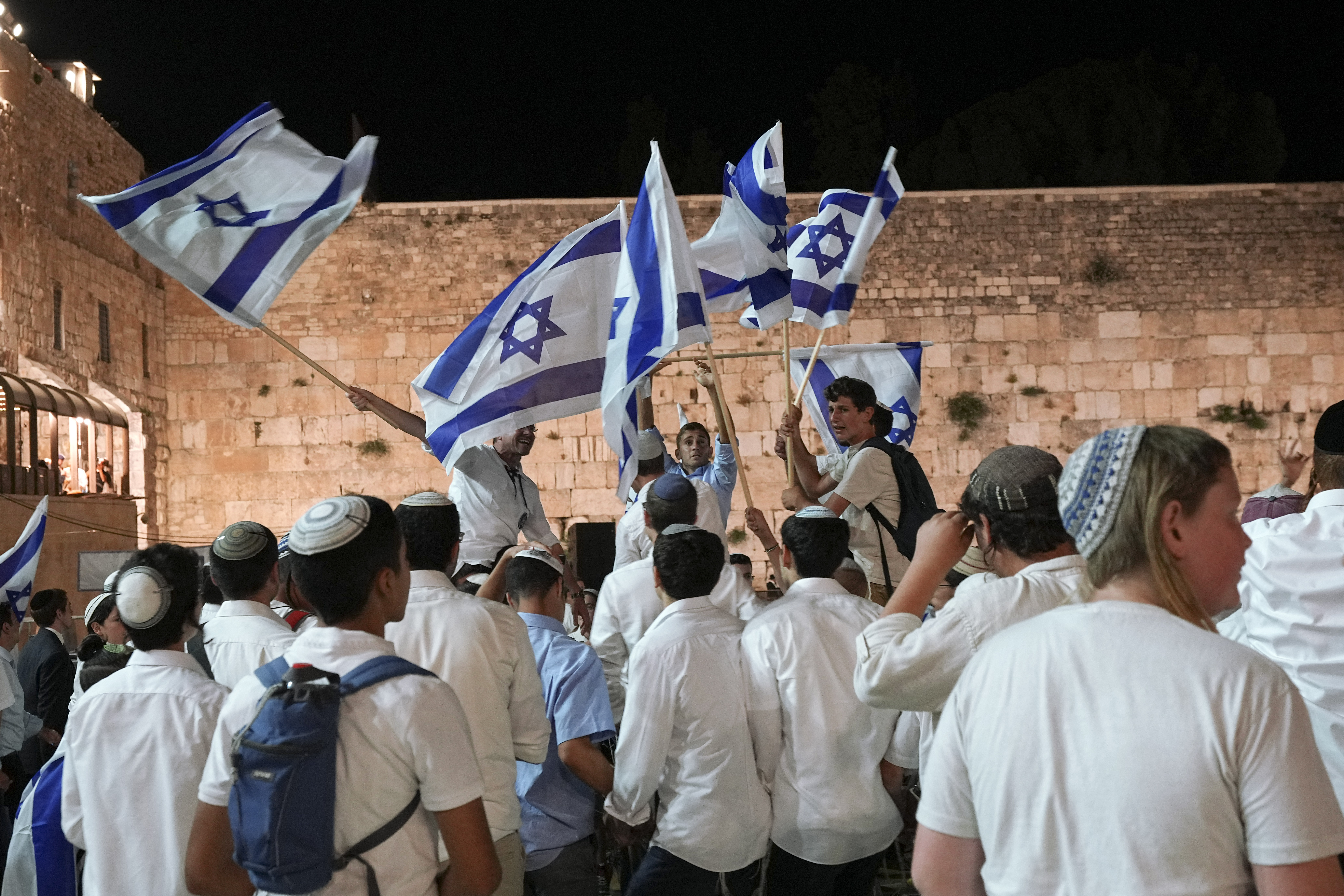 Members of Israeli youth movements dance and wave flags. AP