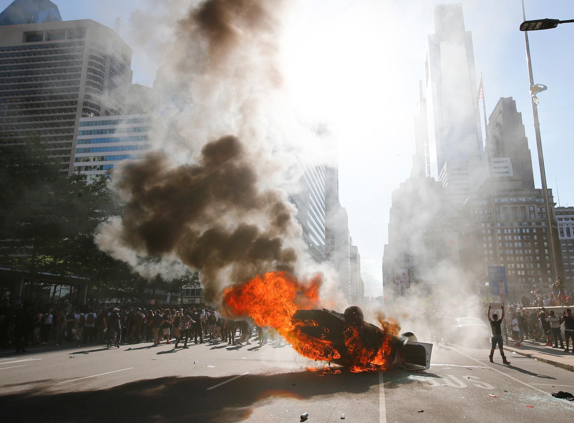 Smoke rises from a fire on a police cruiser in Center City during the Justice for George Floyd Philadelphia Protest in Philadelphia. AP