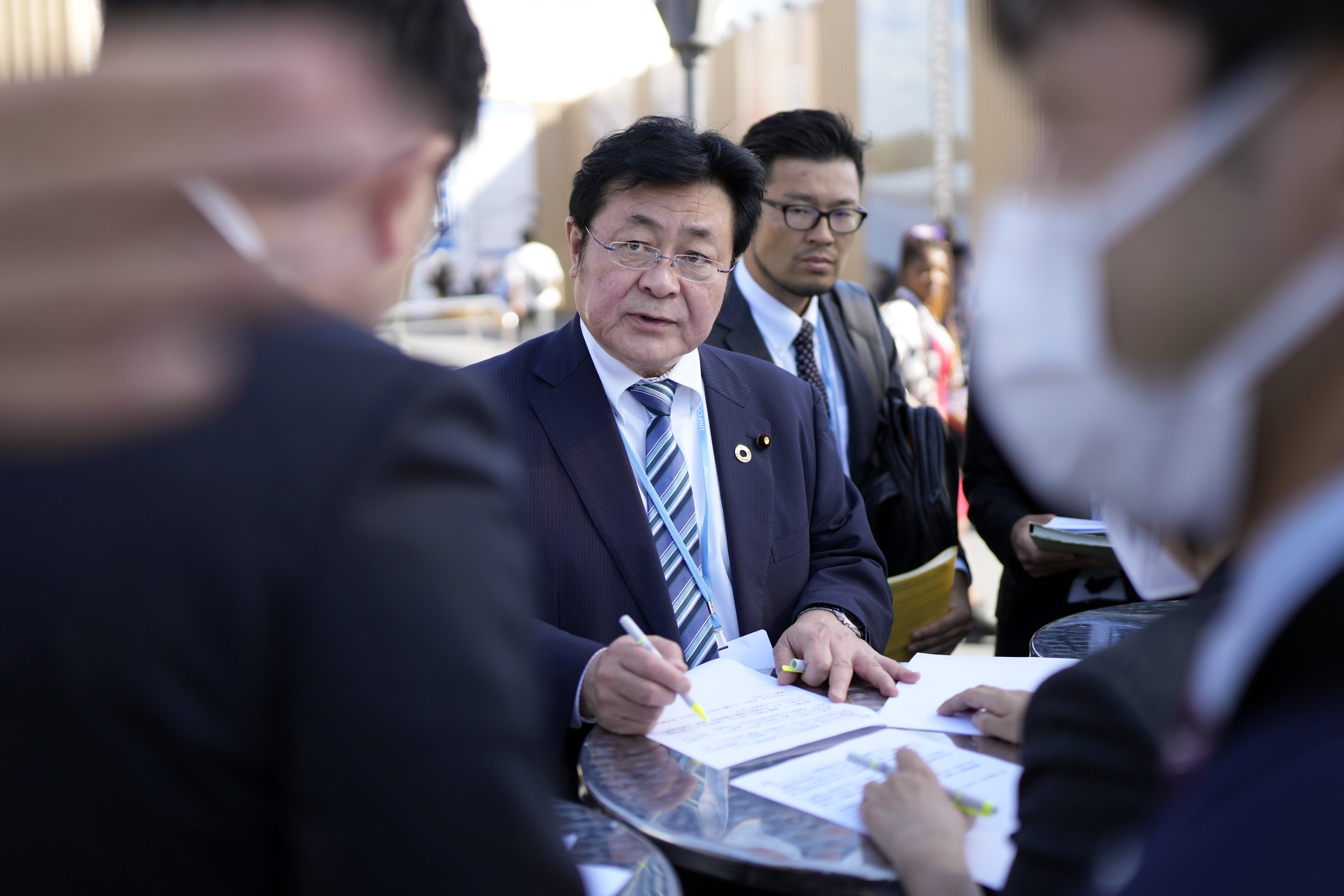 Akihiro Nishimura, minister of the environment of Japan, reviews notes with others at the COP27. AP
