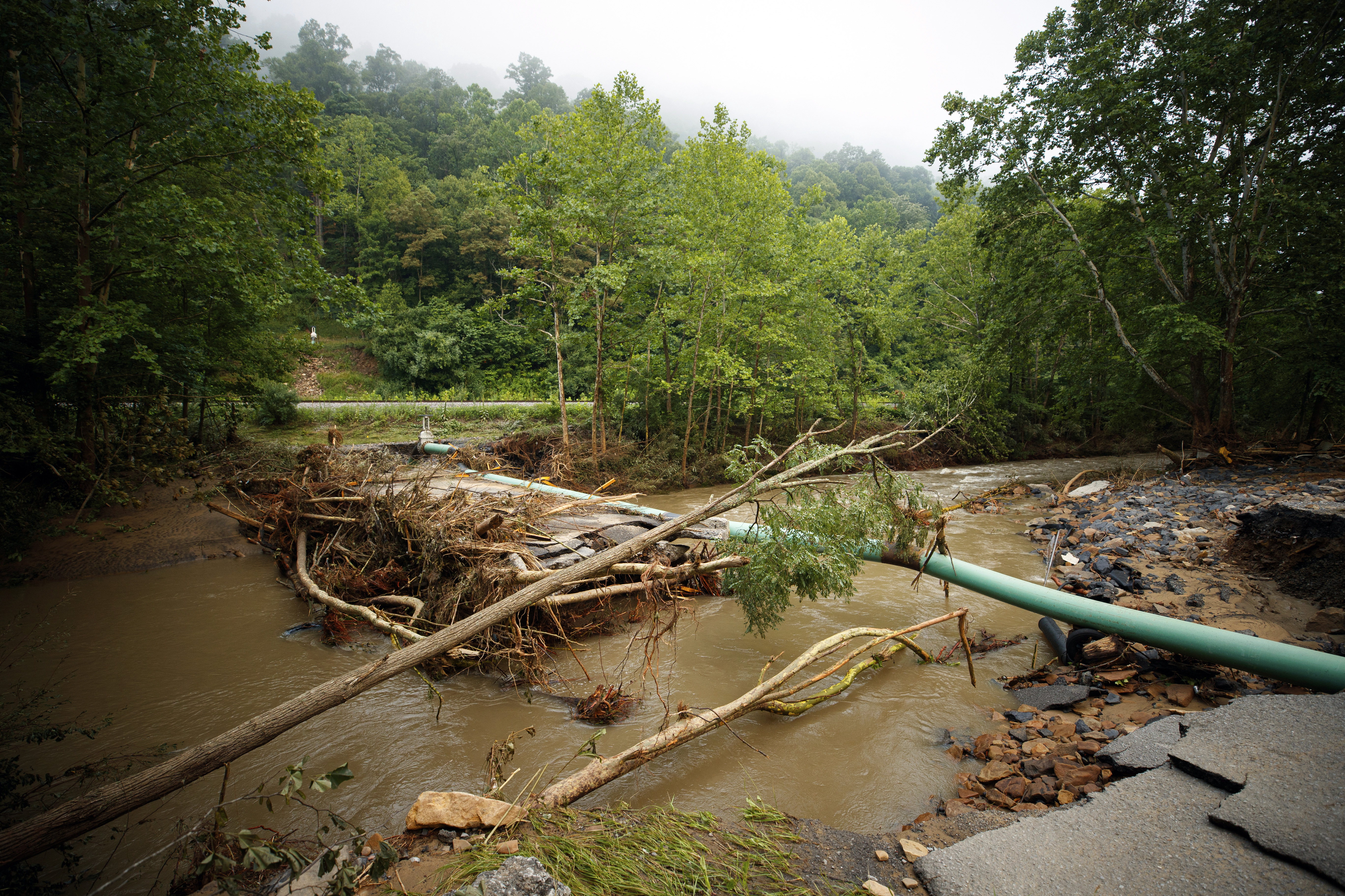 A collapsed bridge sits in the river.