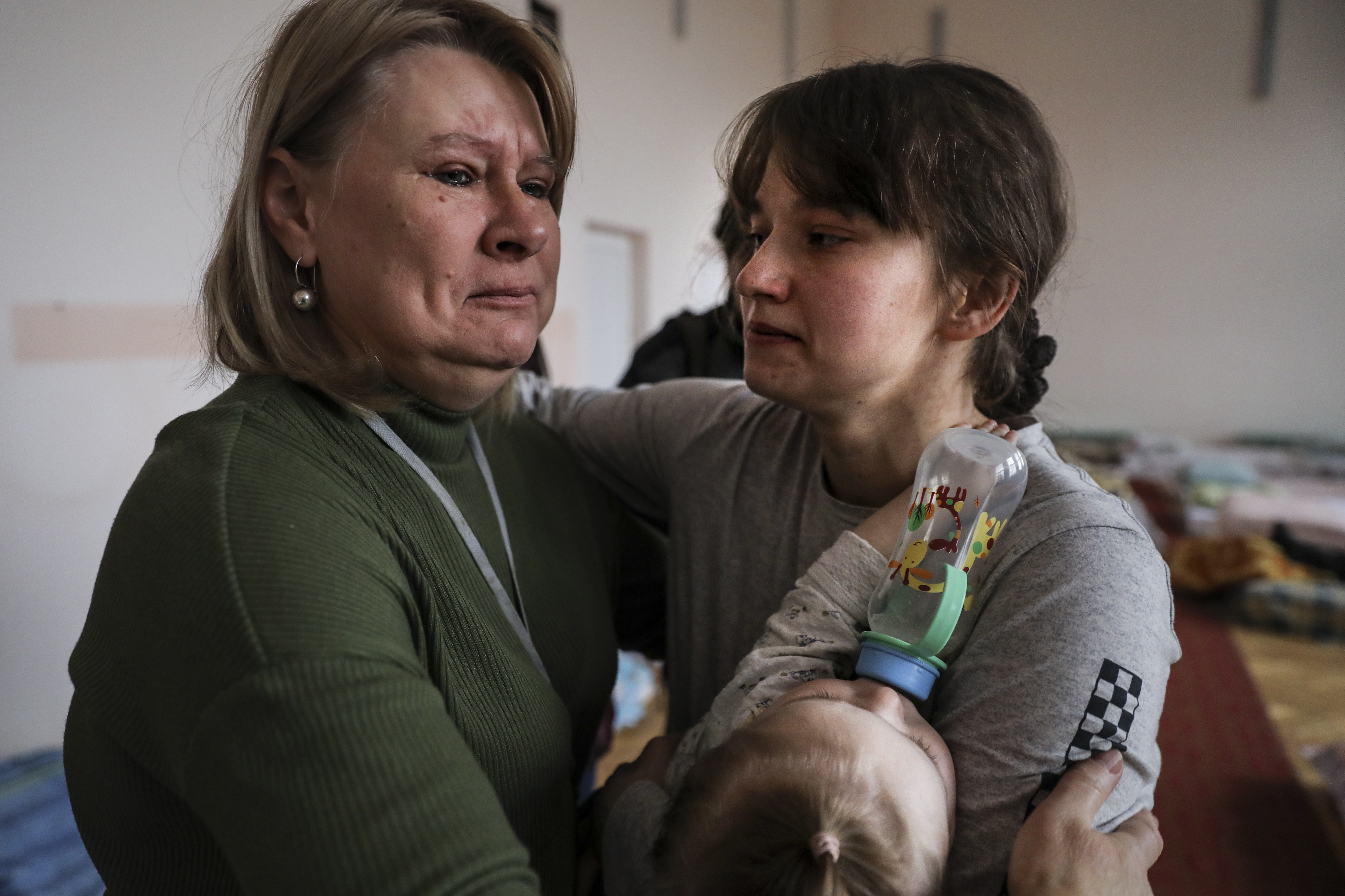 Lessa, left, director of a nursery school turned into a refugee shelter, cries as she hugs Olega, who arrived from Kyiv with her baby, near Lviv. EPA