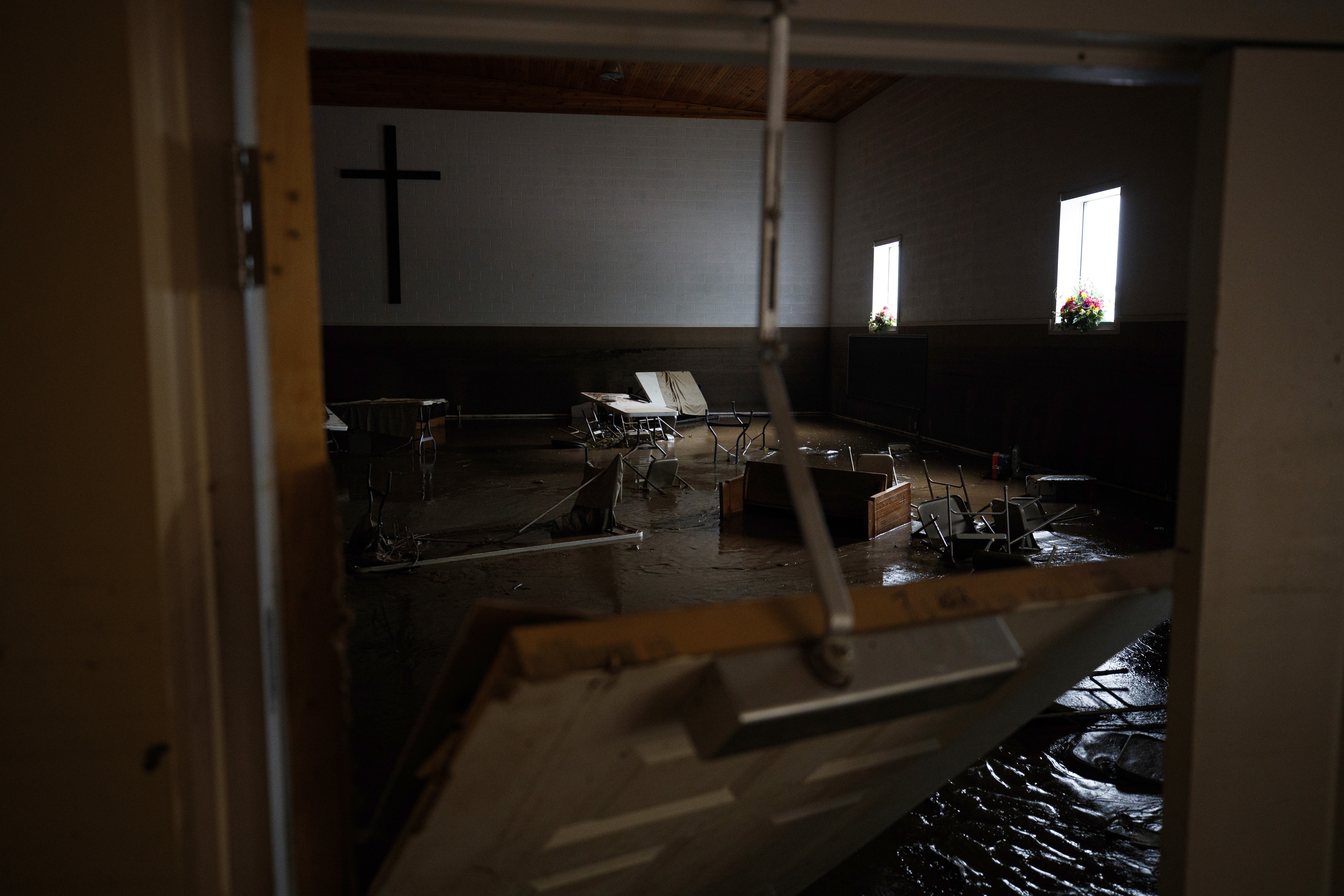 Chairs and pews sink down into mud inside the Baptist Bible Church.
